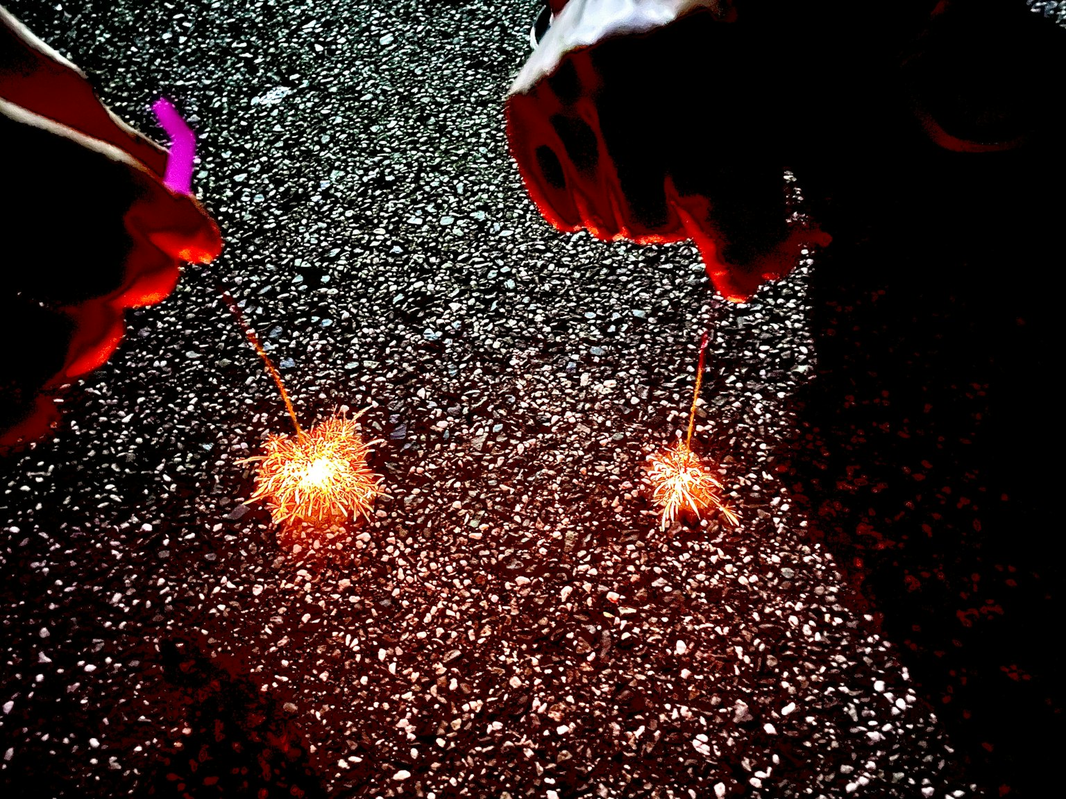 Fumogeni tenuti in mano che illuminano una superficie scura
