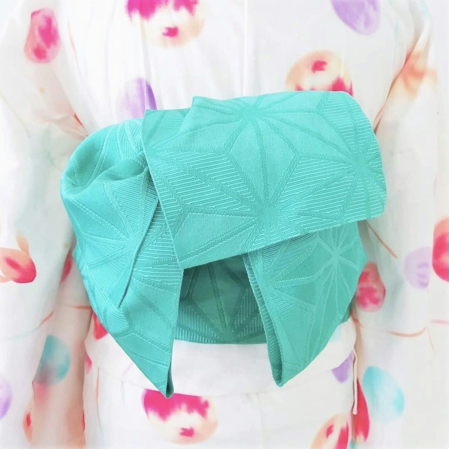 Detail kimono dengan simpul obi turquoise di belakang