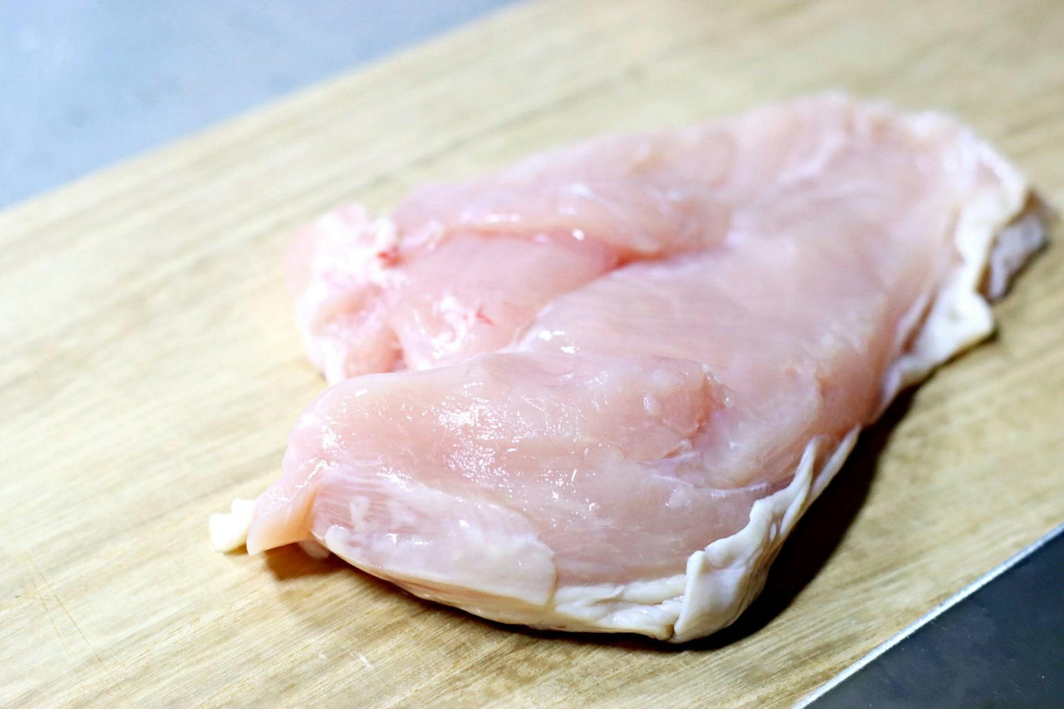生鸡胸肉放在木砧板上
