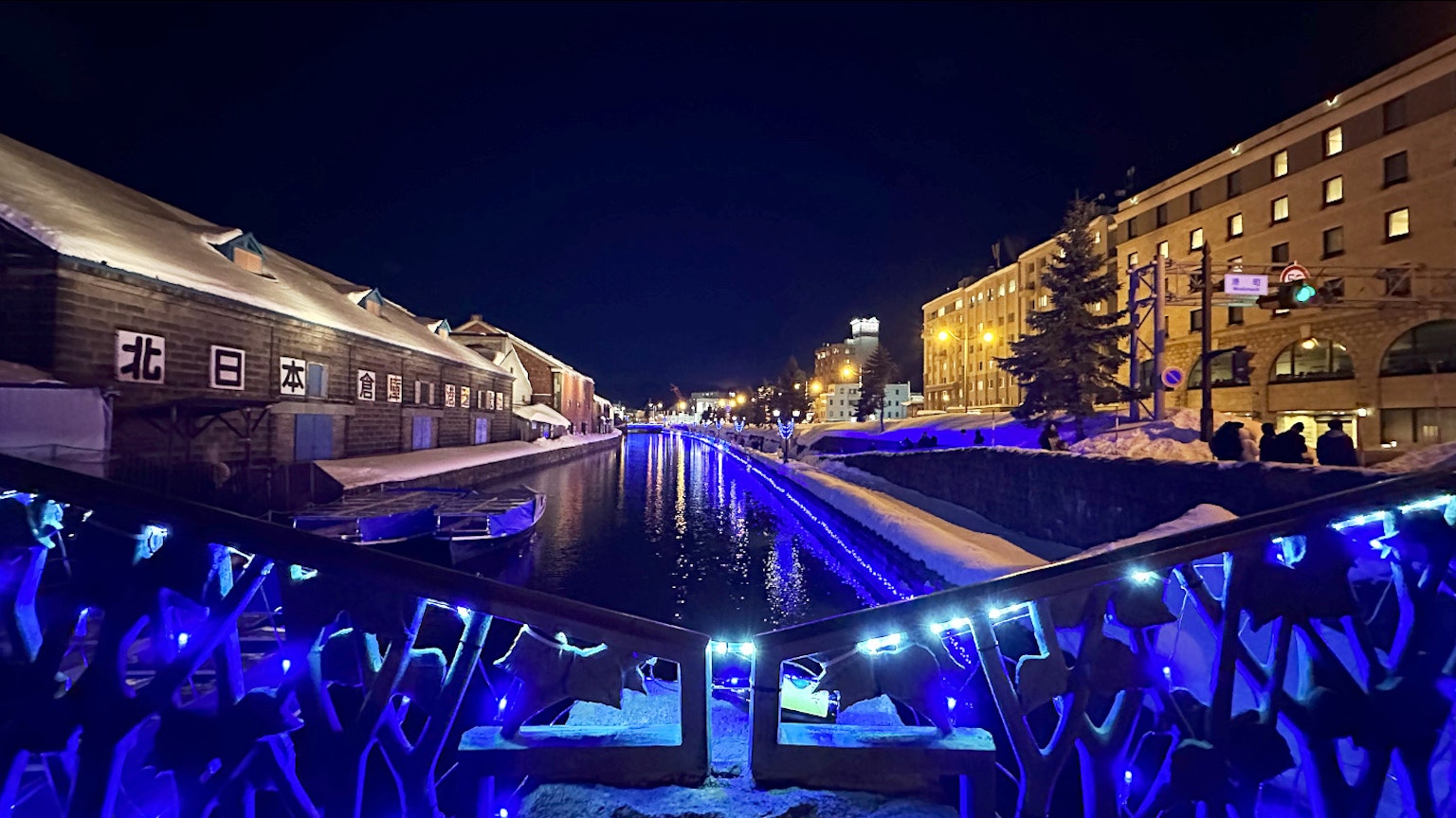 夜晚被藍色燈光照亮的運河和背景建築的景觀