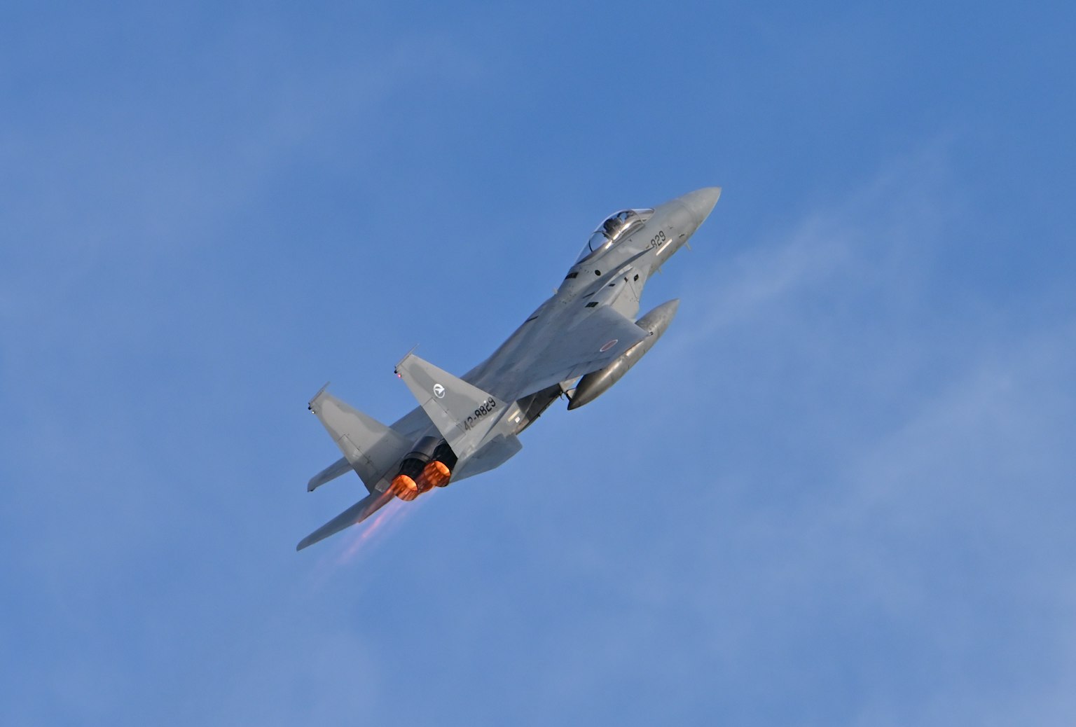 Image of a fighter jet climbing sharply against a blue sky
