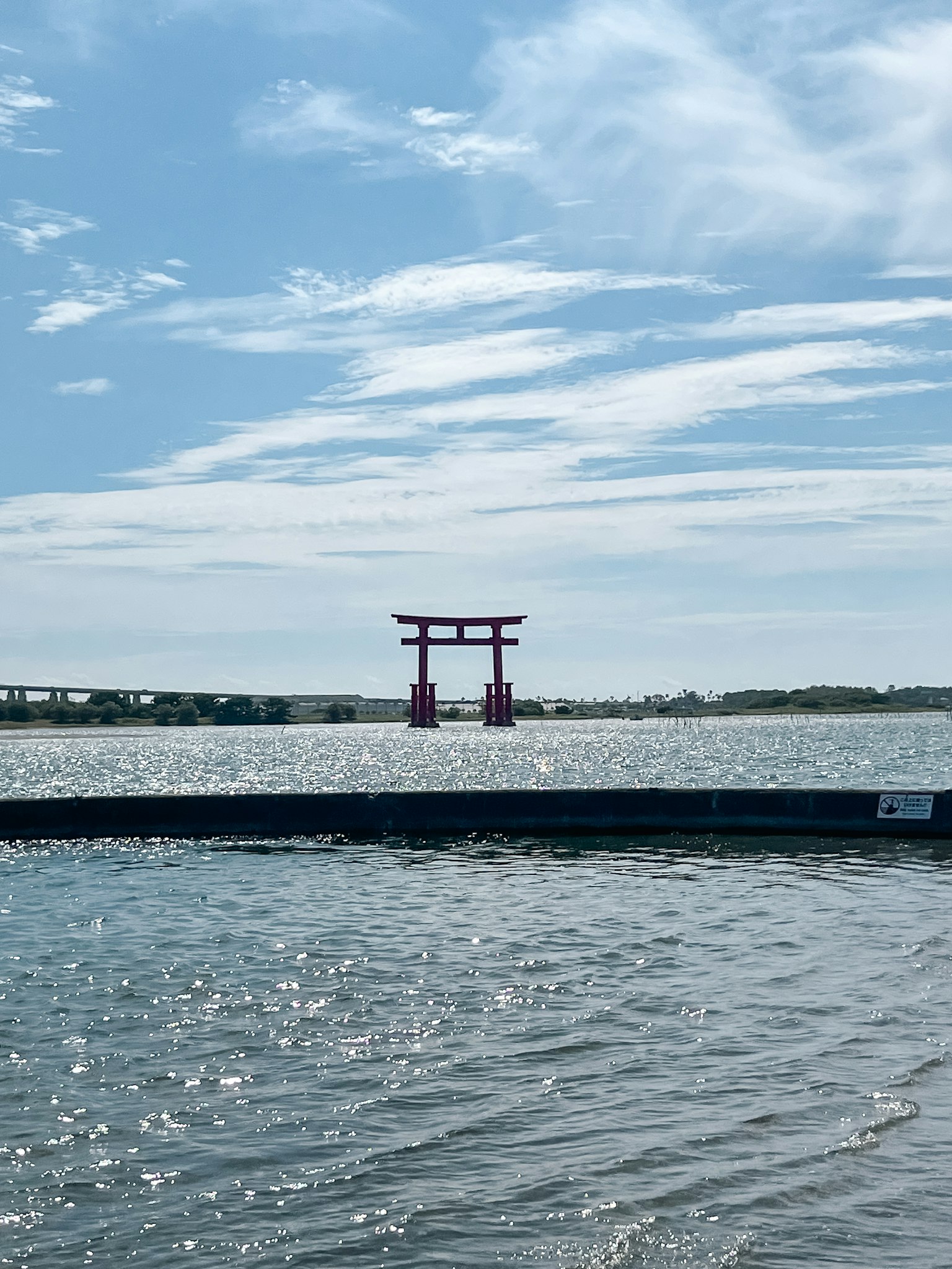 Torii rosso sull'acqua con cielo blu