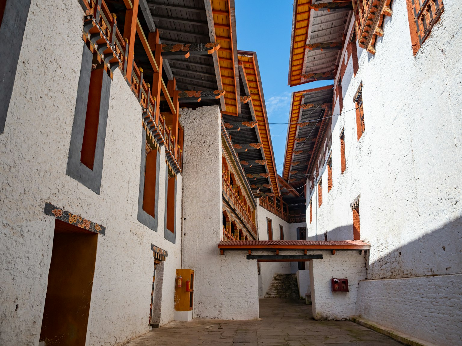 Vista del patio de un edificio tradicional con paredes blancas y techos de madera