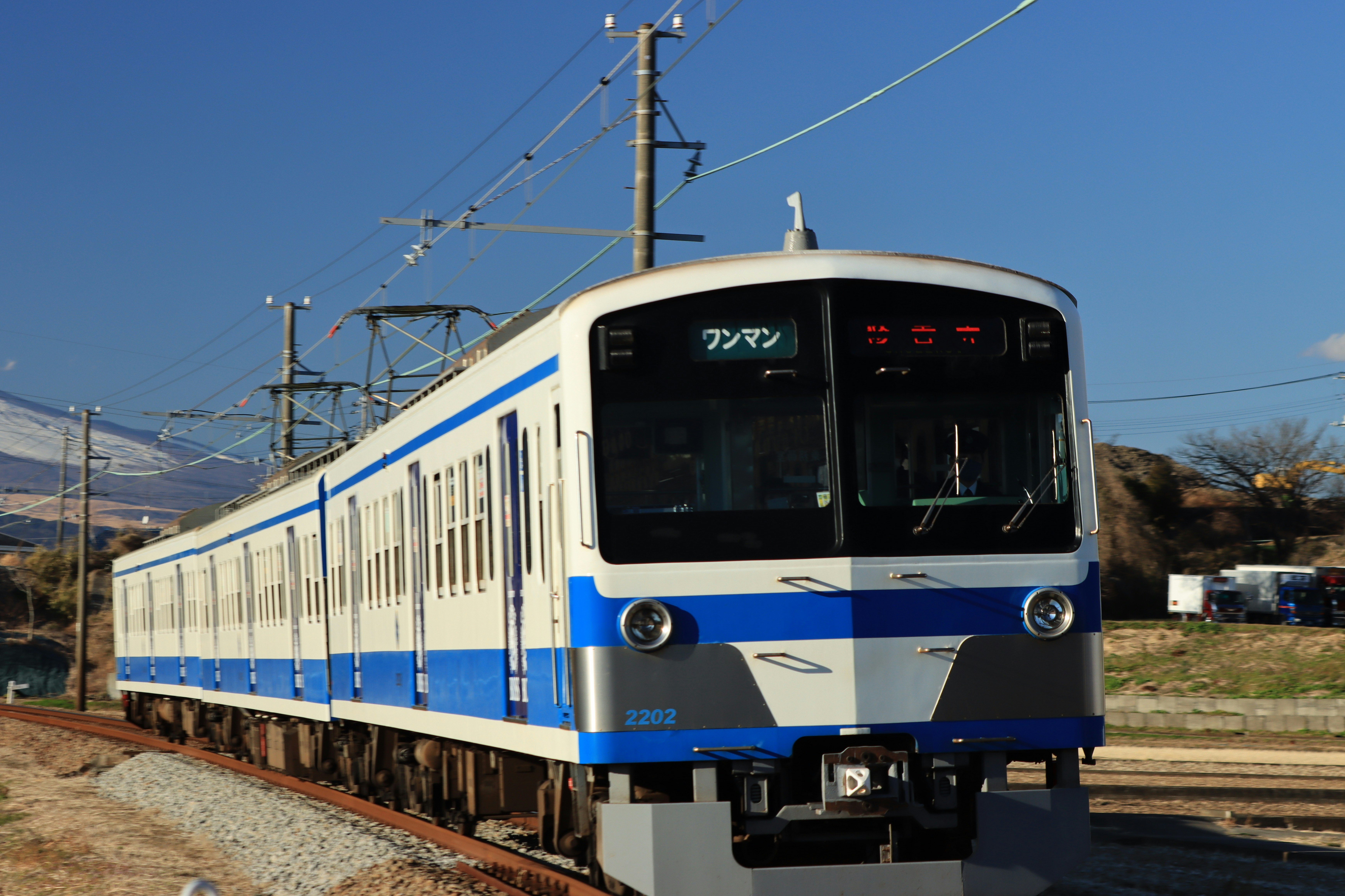 青空の下を走る青白い電車の正面