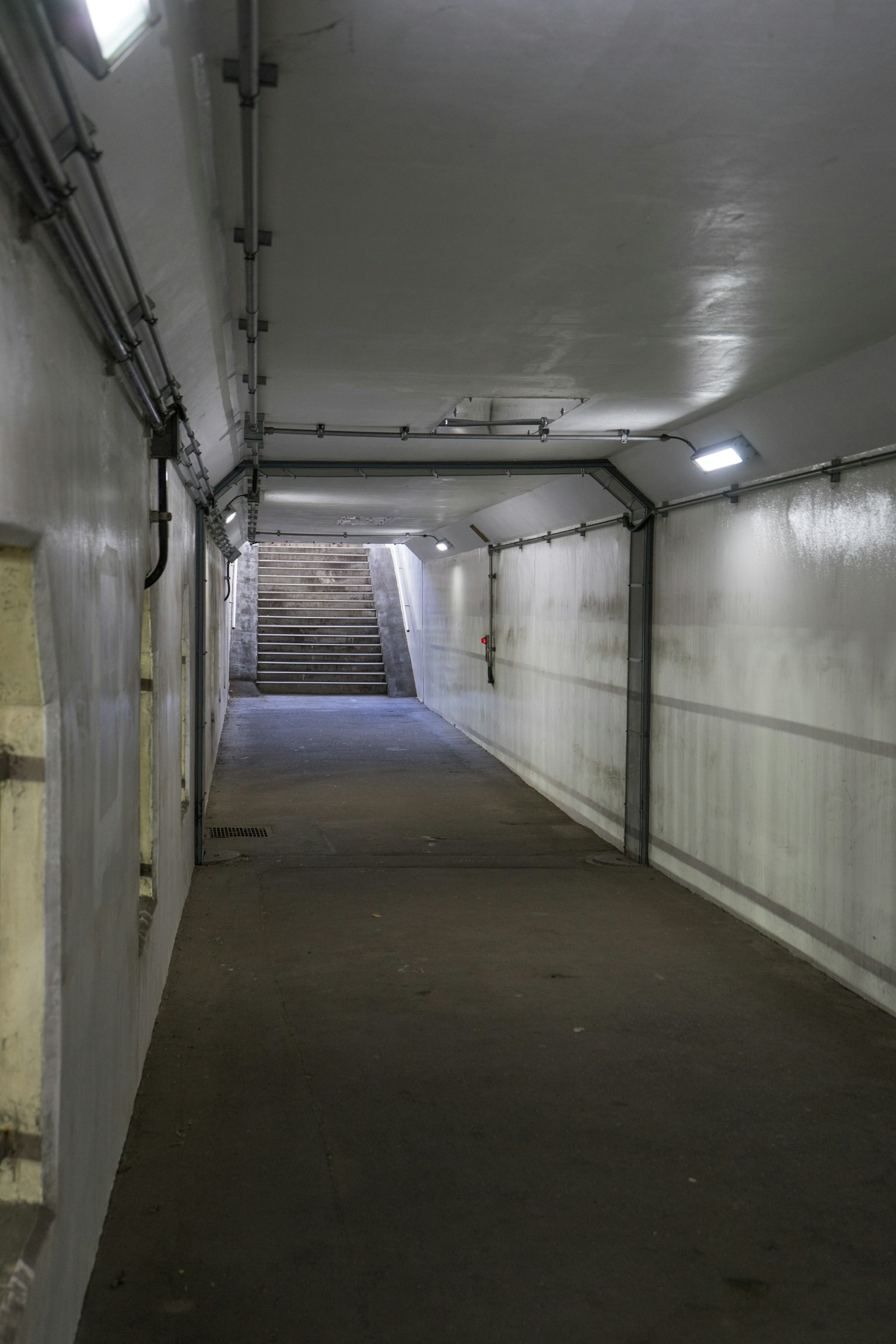 Pasillo subterráneo brillante que conduce a escaleras