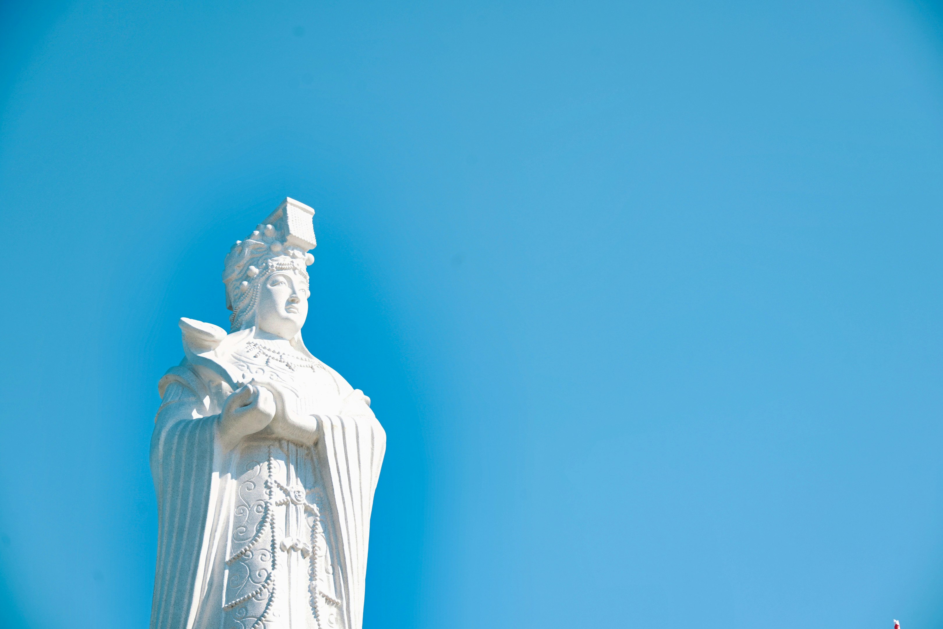青空の下の白い彫像と人物像