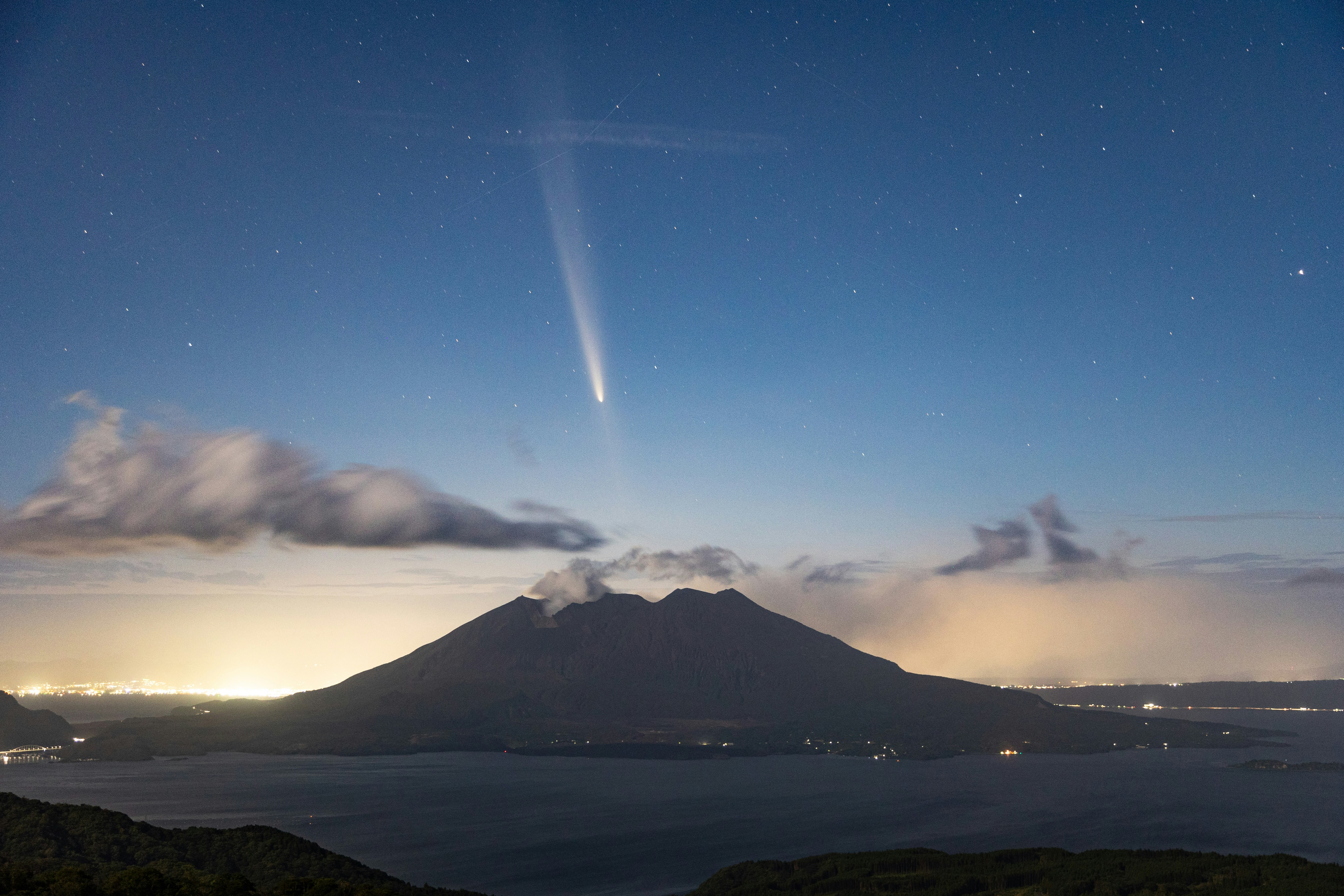 夜空の星と富士山のシルエットが見える海辺の眺望