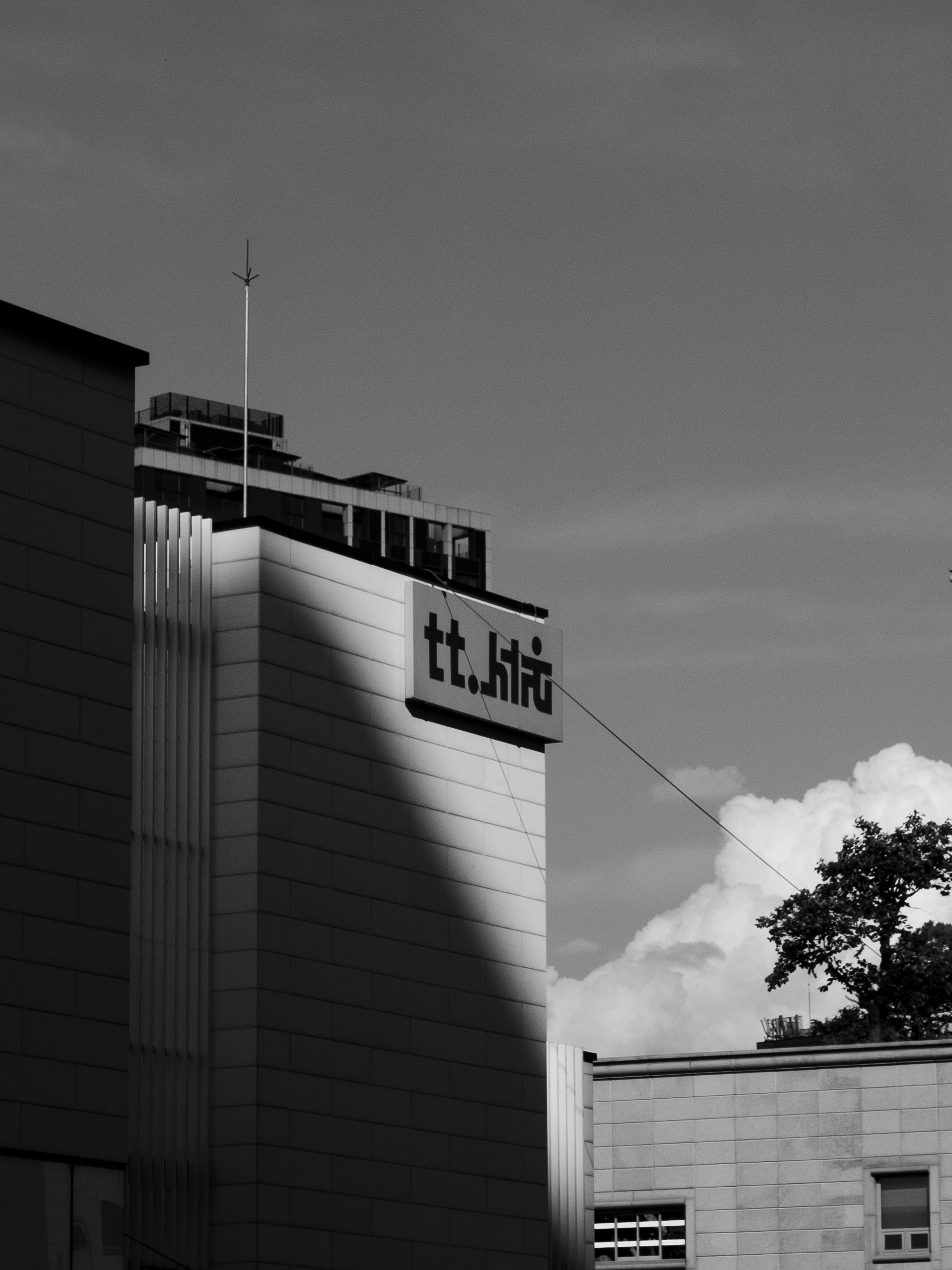 建物の壁面に掲げられた看板と空の雲