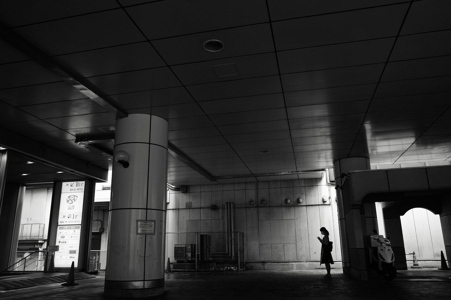 Silueta de una persona de pie en un espacio oscuro con arquitectura moderna