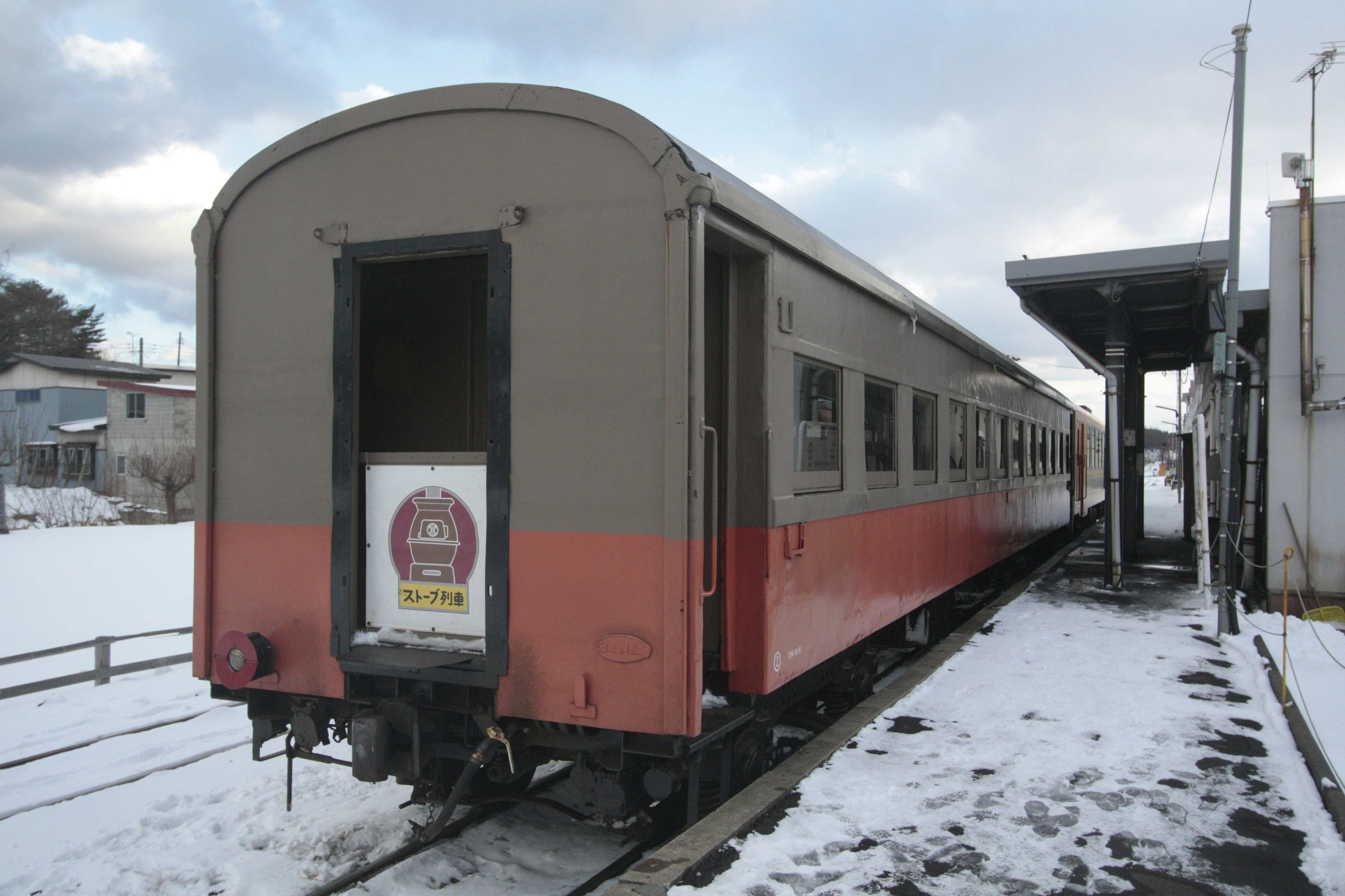 停在積雪月台上的紅色客運列車後視