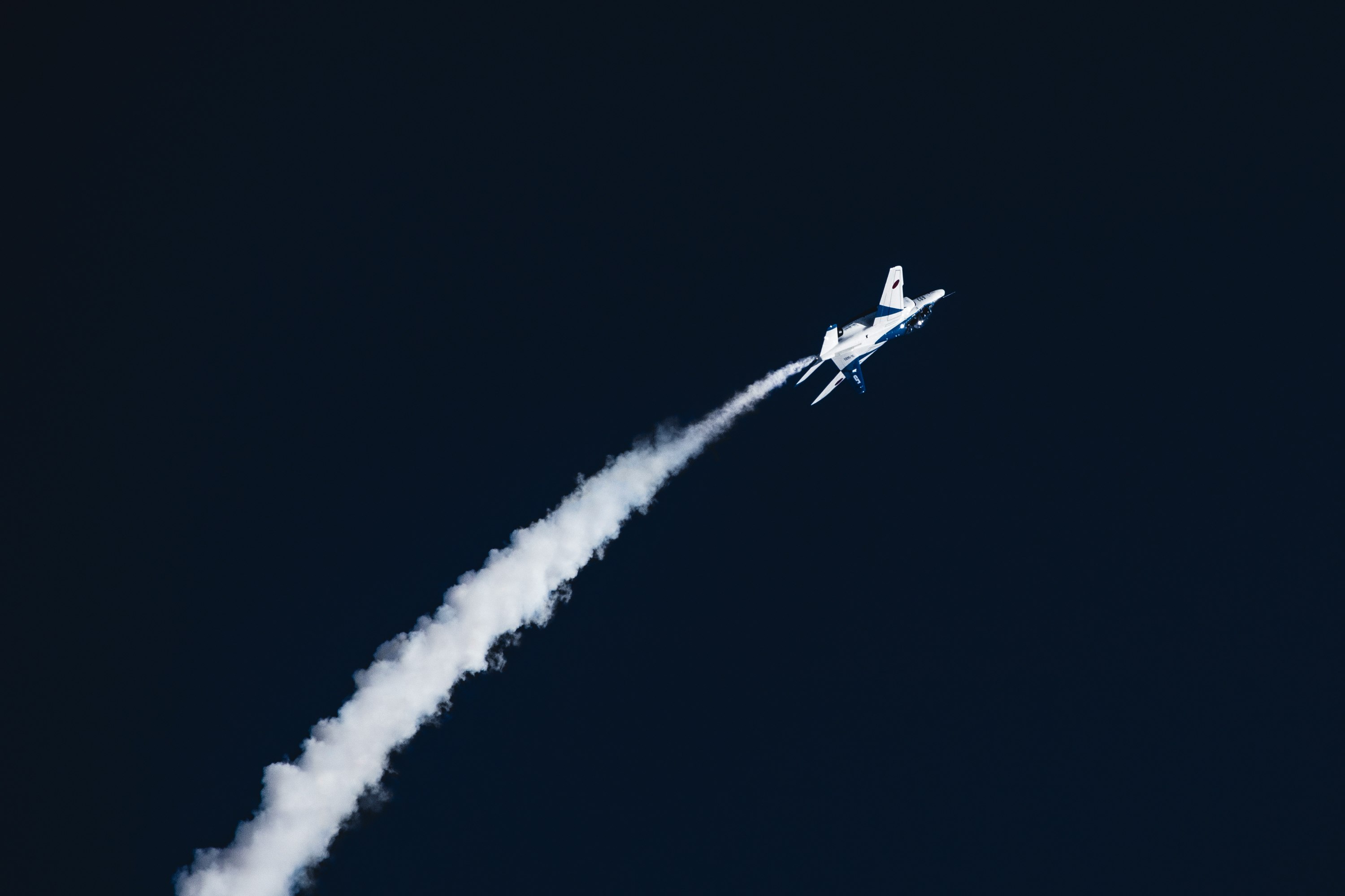 夜空を飛ぶジェット機の飛行雲