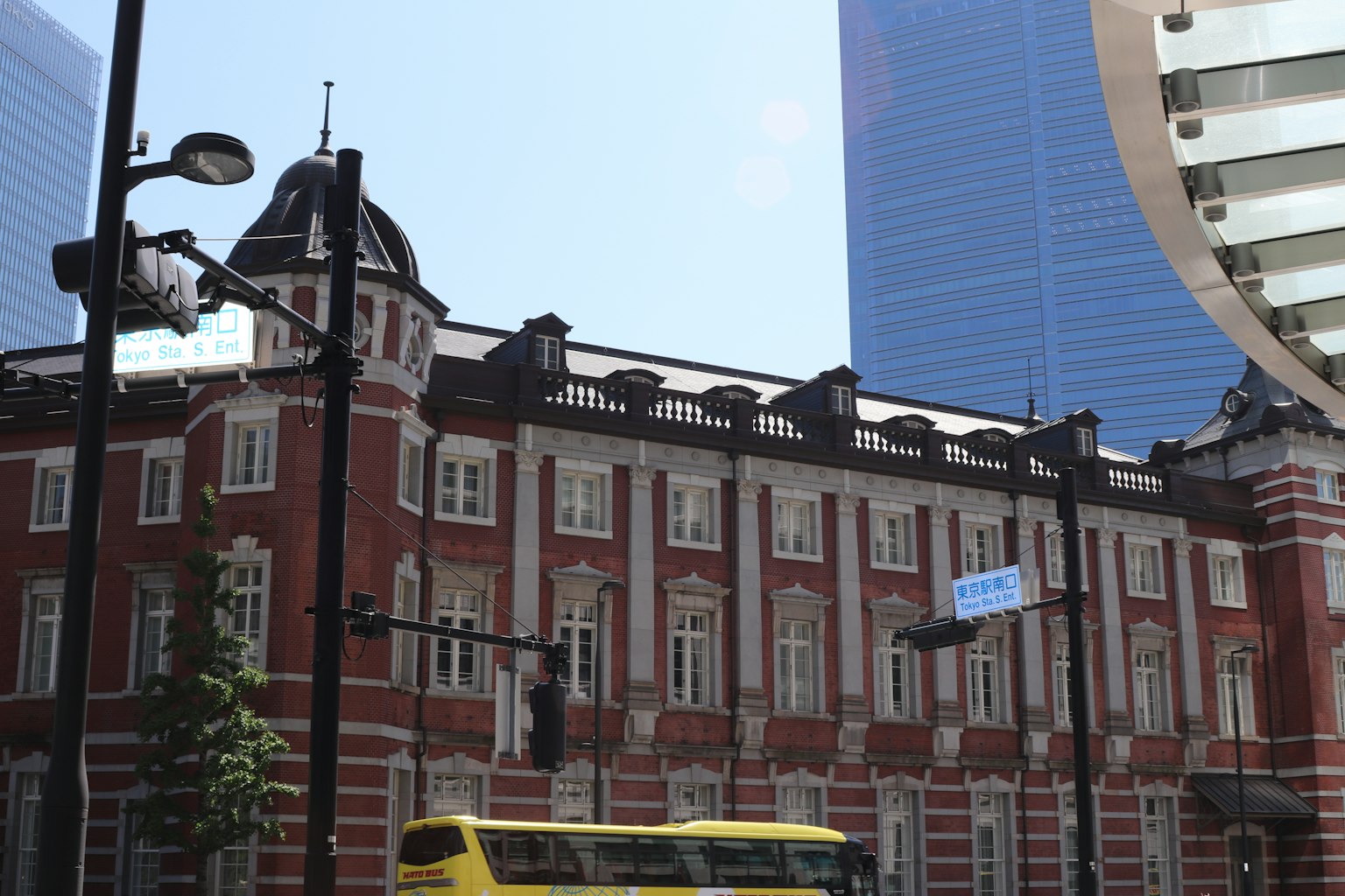 อาคารสถานีโตเกียวที่มีประวัติศาสตร์พร้อมตึกระฟ้าสมัยใหม่ในพื้นหลัง