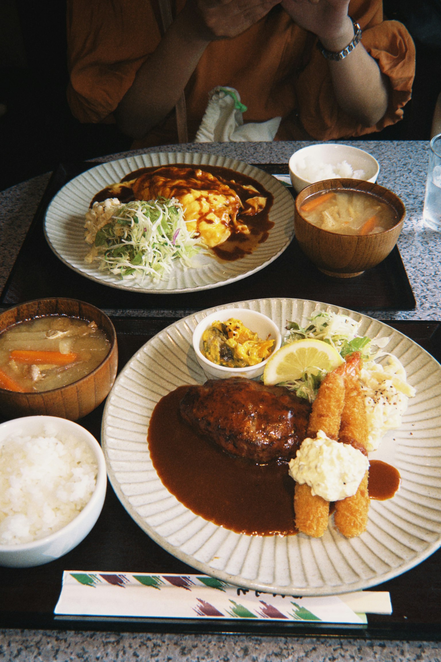 맛있는 일본식 식사로 햄버거 스테이크, 샐러드, 밥, 미소국이 포함되어 있다