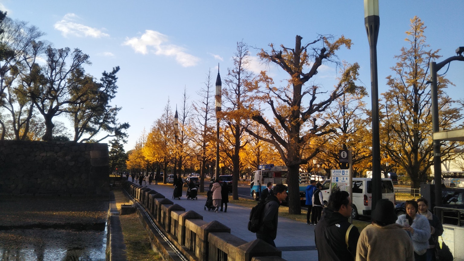 Herbstszene mit einem baumgesäumten Weg und Menschen