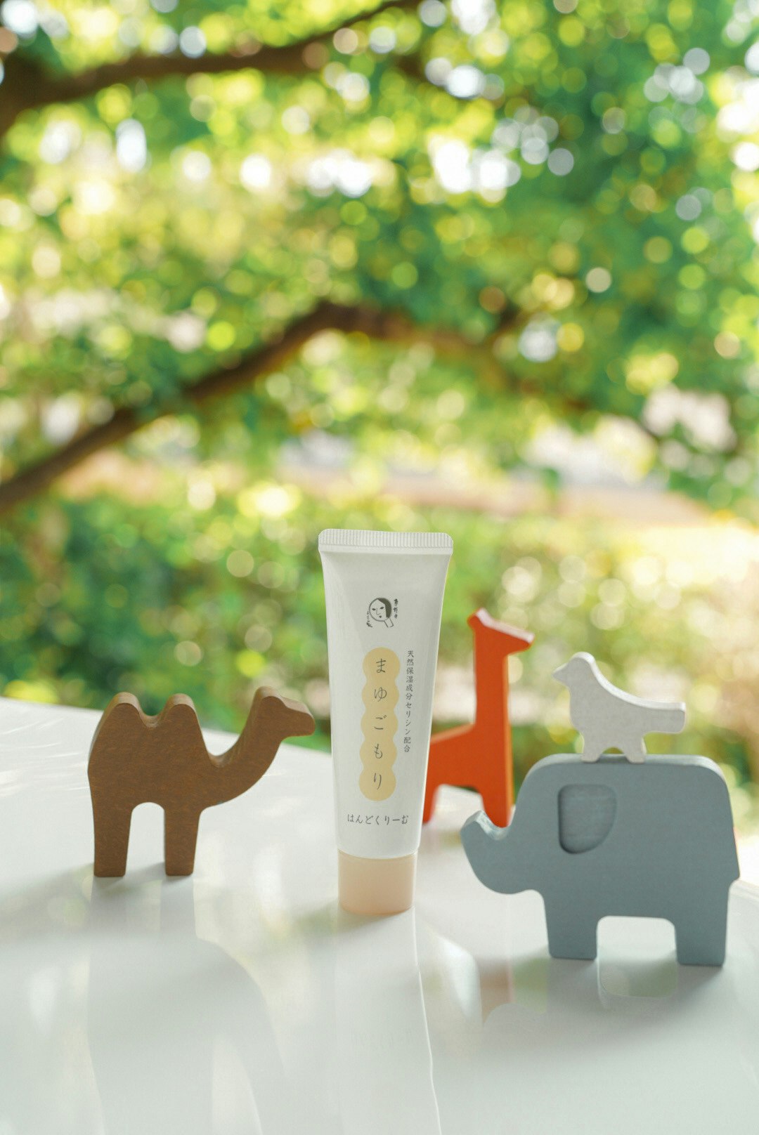 木の動物オブジェと手肌用ハンドクリームのあるテーブル