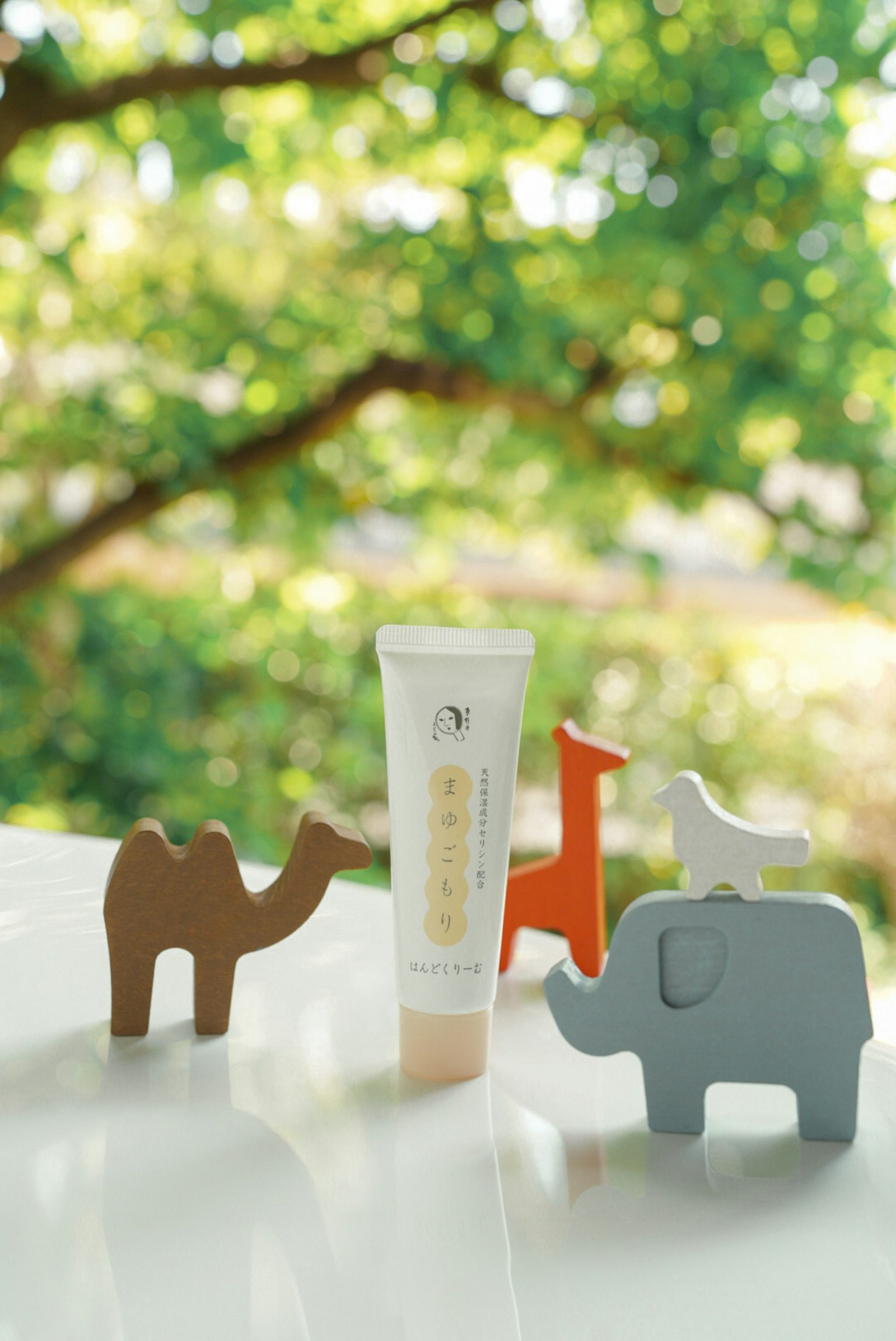 色彩繽紛的動物小雕像和化妝品管放置在綠色背景前