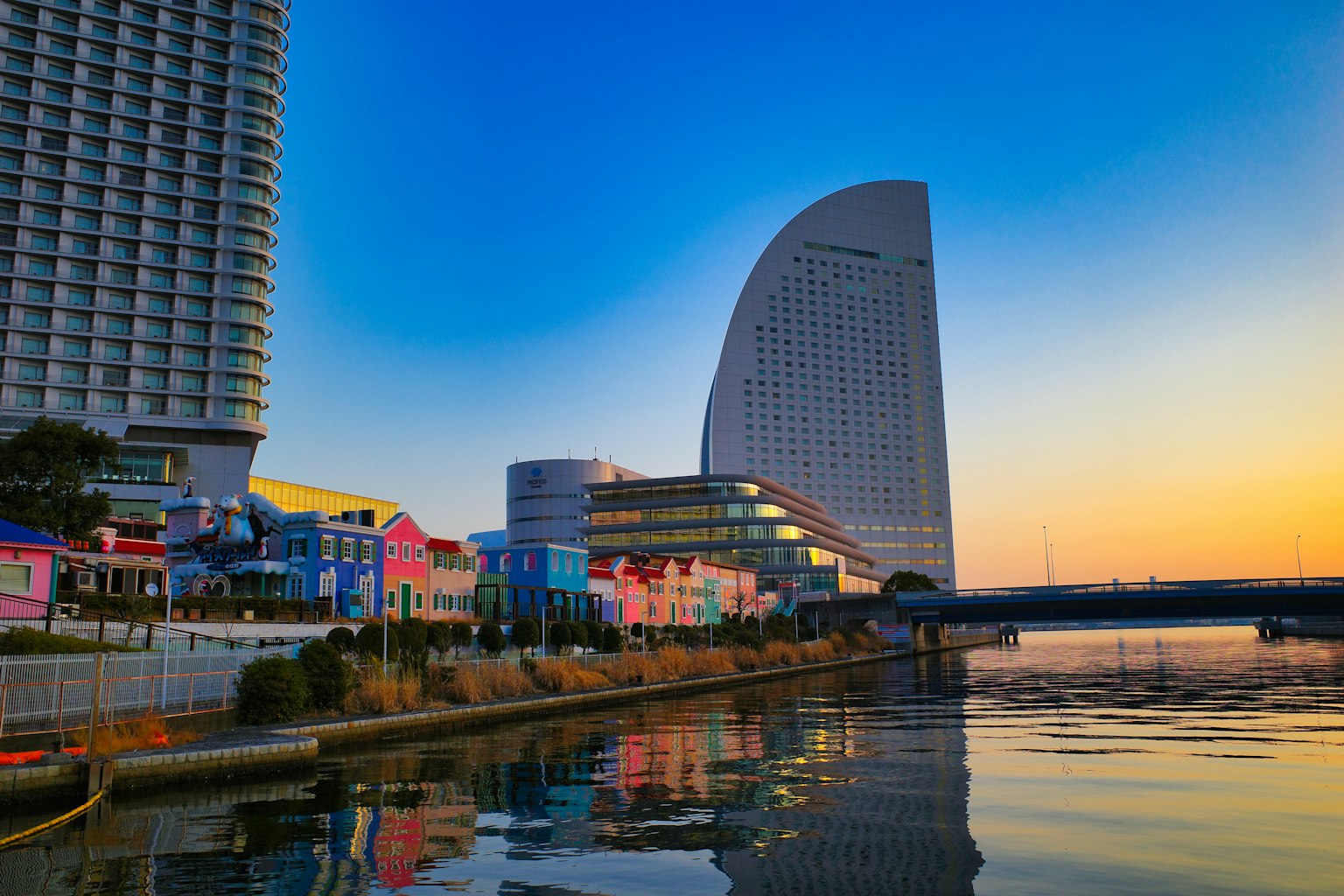 Vue du front de mer de Yokohama avec des bâtiments colorés et un gratte-ciel moderne ciel de coucher de soleil se reflétant sur l'eau