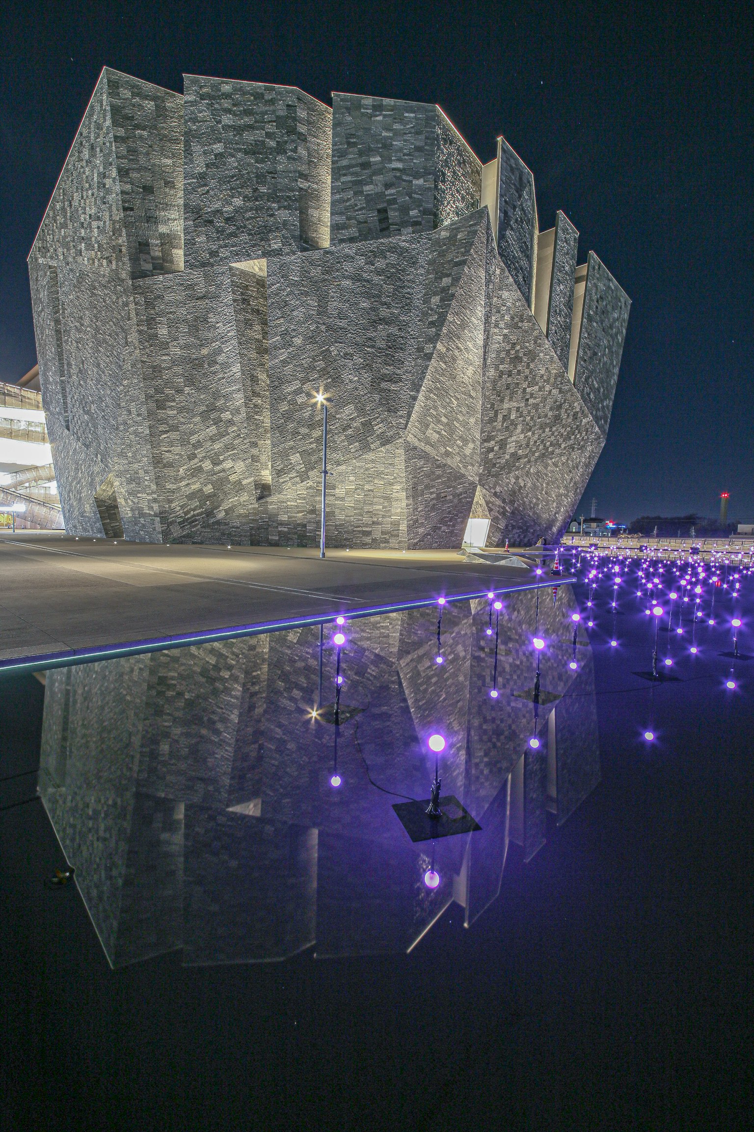 Design unico di un edificio moderno riflesso sull'acqua di notte