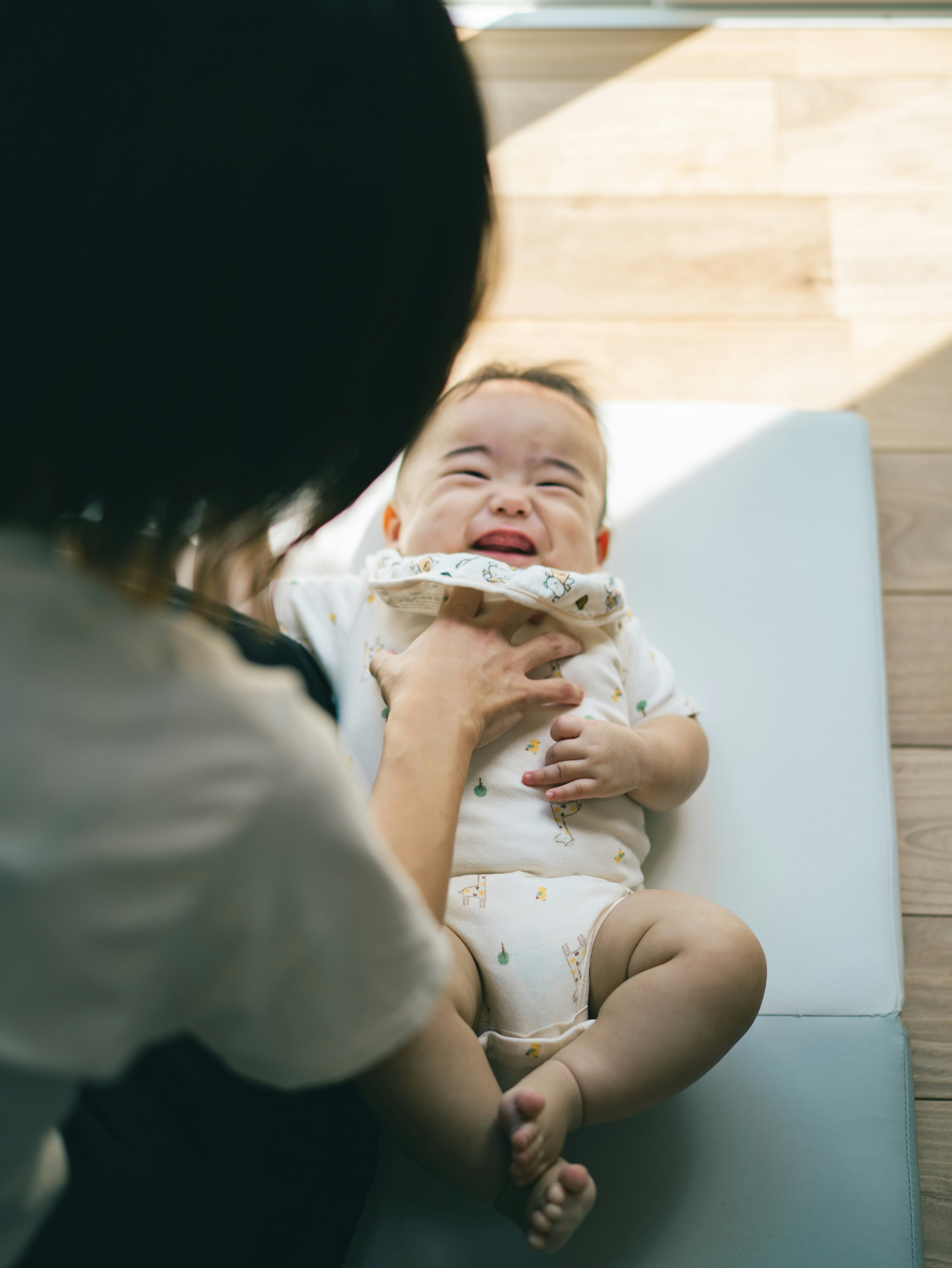 抱き上げられて笑う赤ちゃん