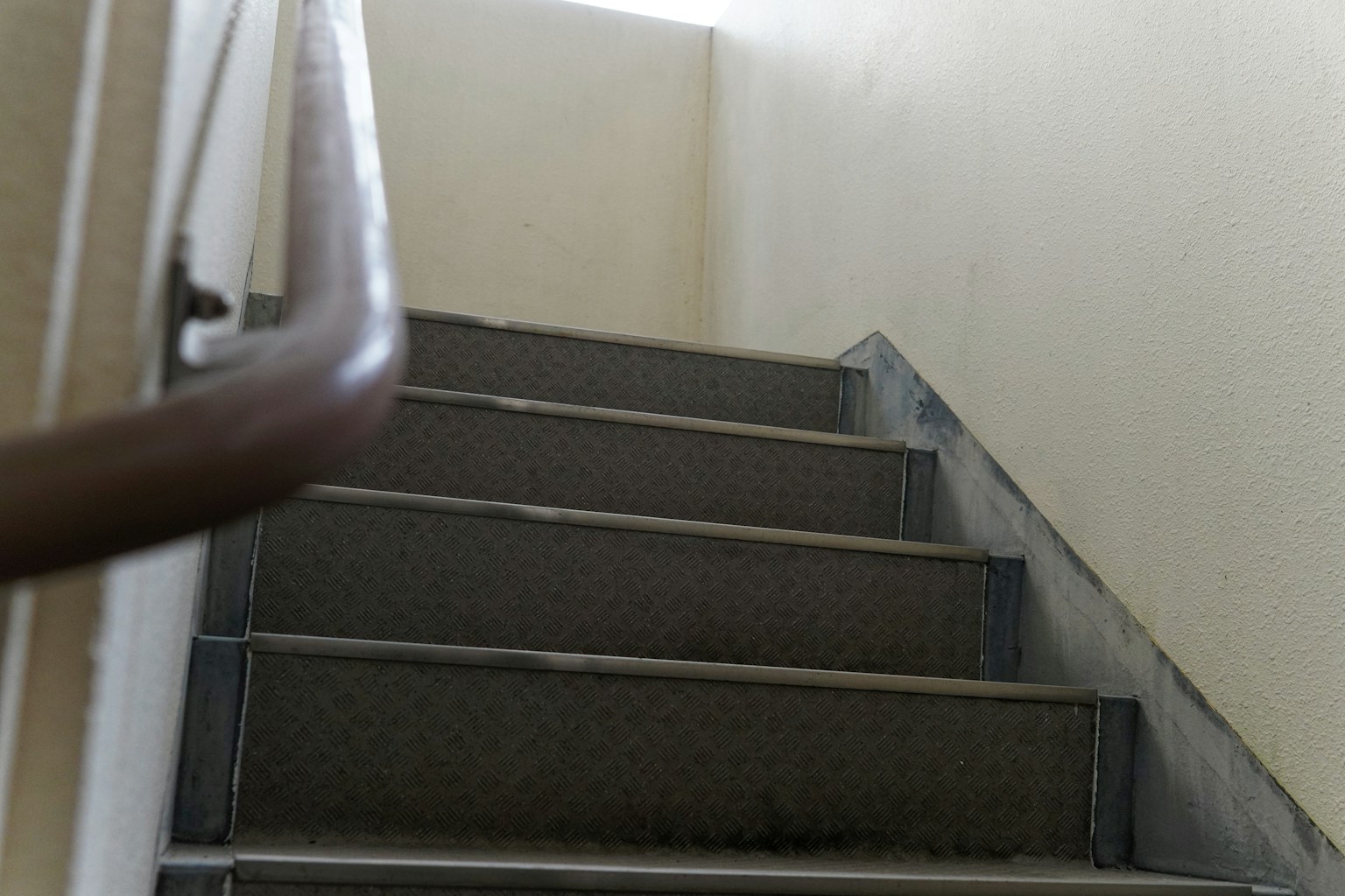 มุมมองภายในของบันไดที่มีราวจับและขั้นบันไดคอนกรีต