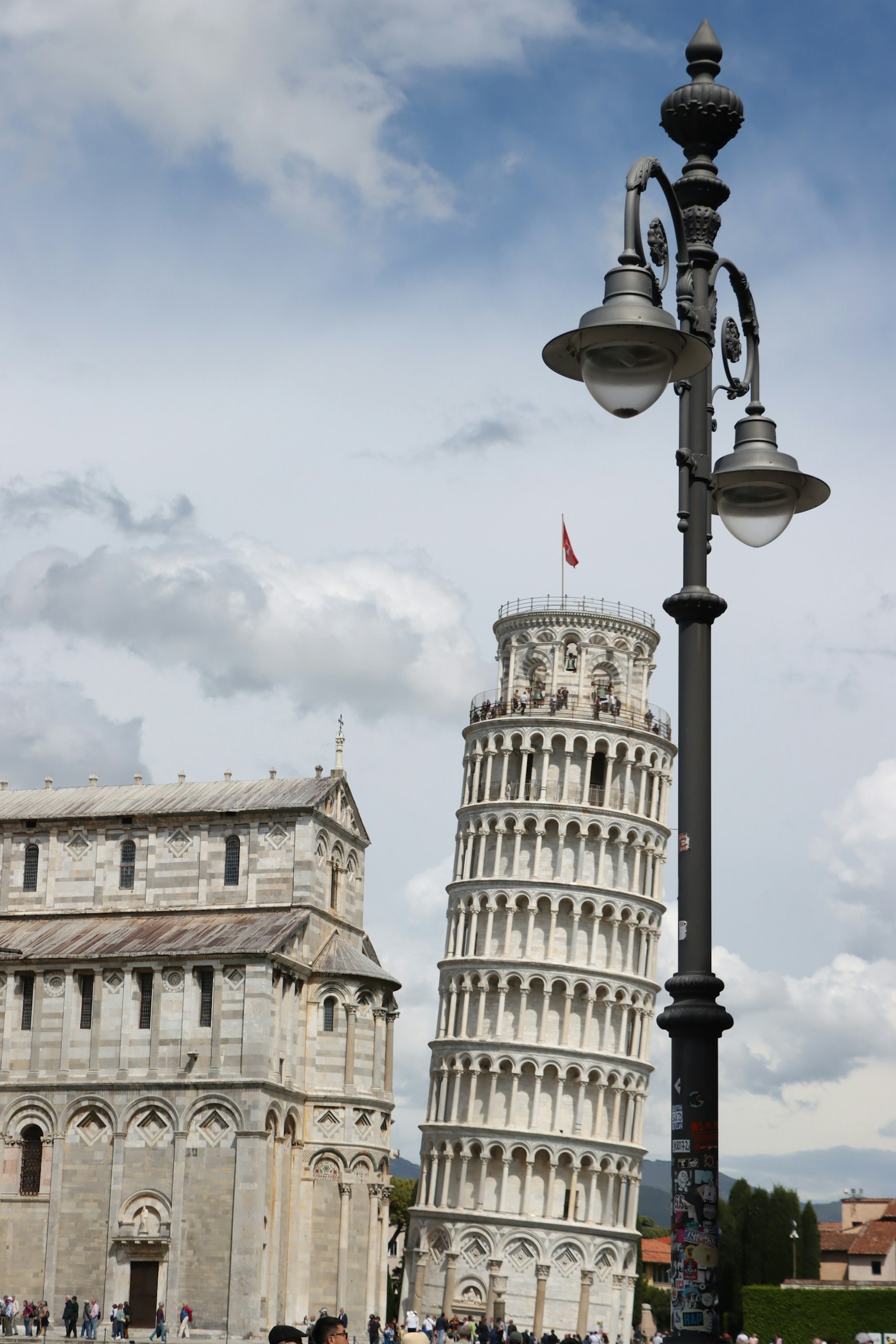 Leaning Tower of Pisa with historical building and street lamp