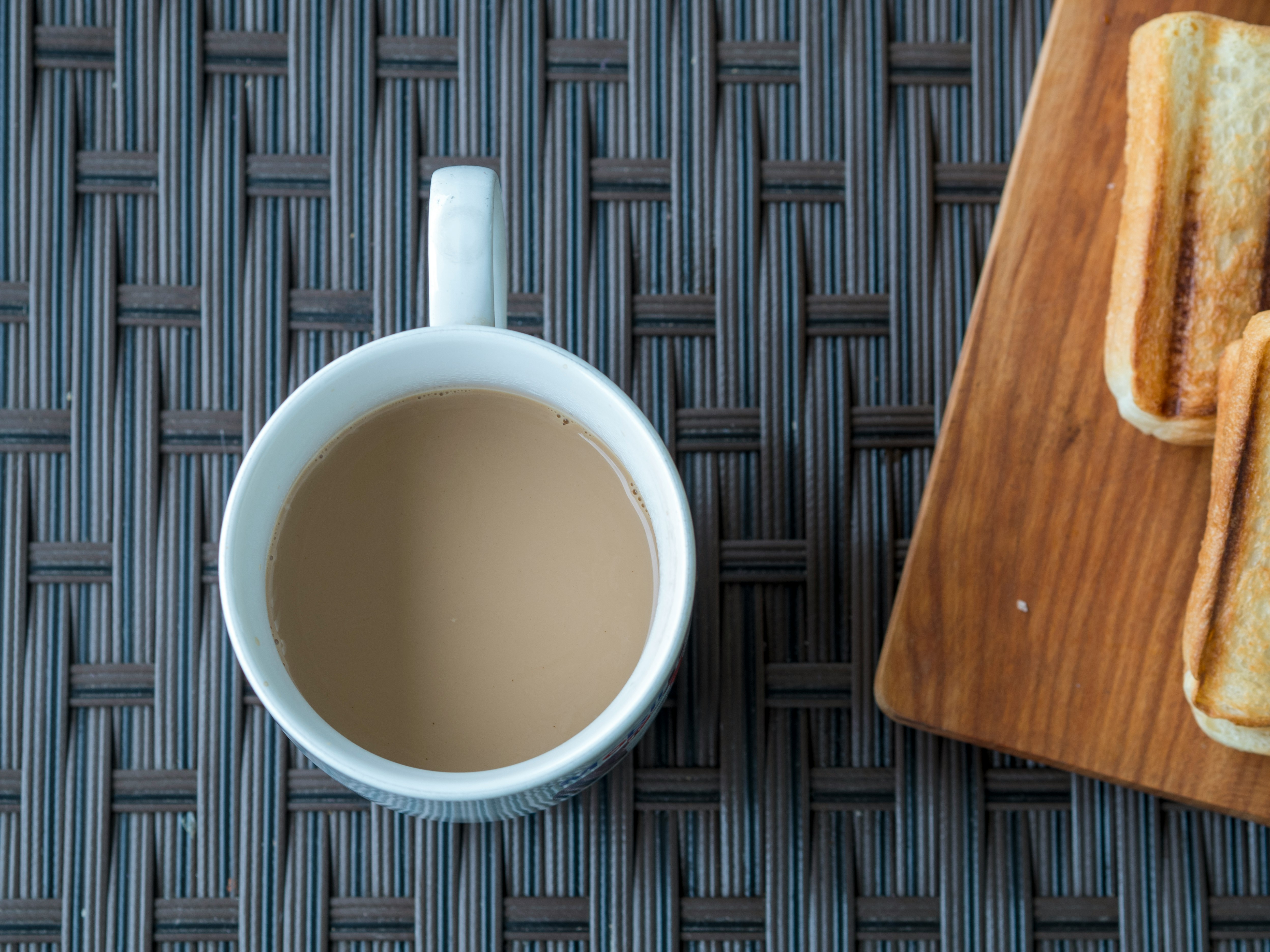 morning drink in a mug on a woven mat with a wooden tray