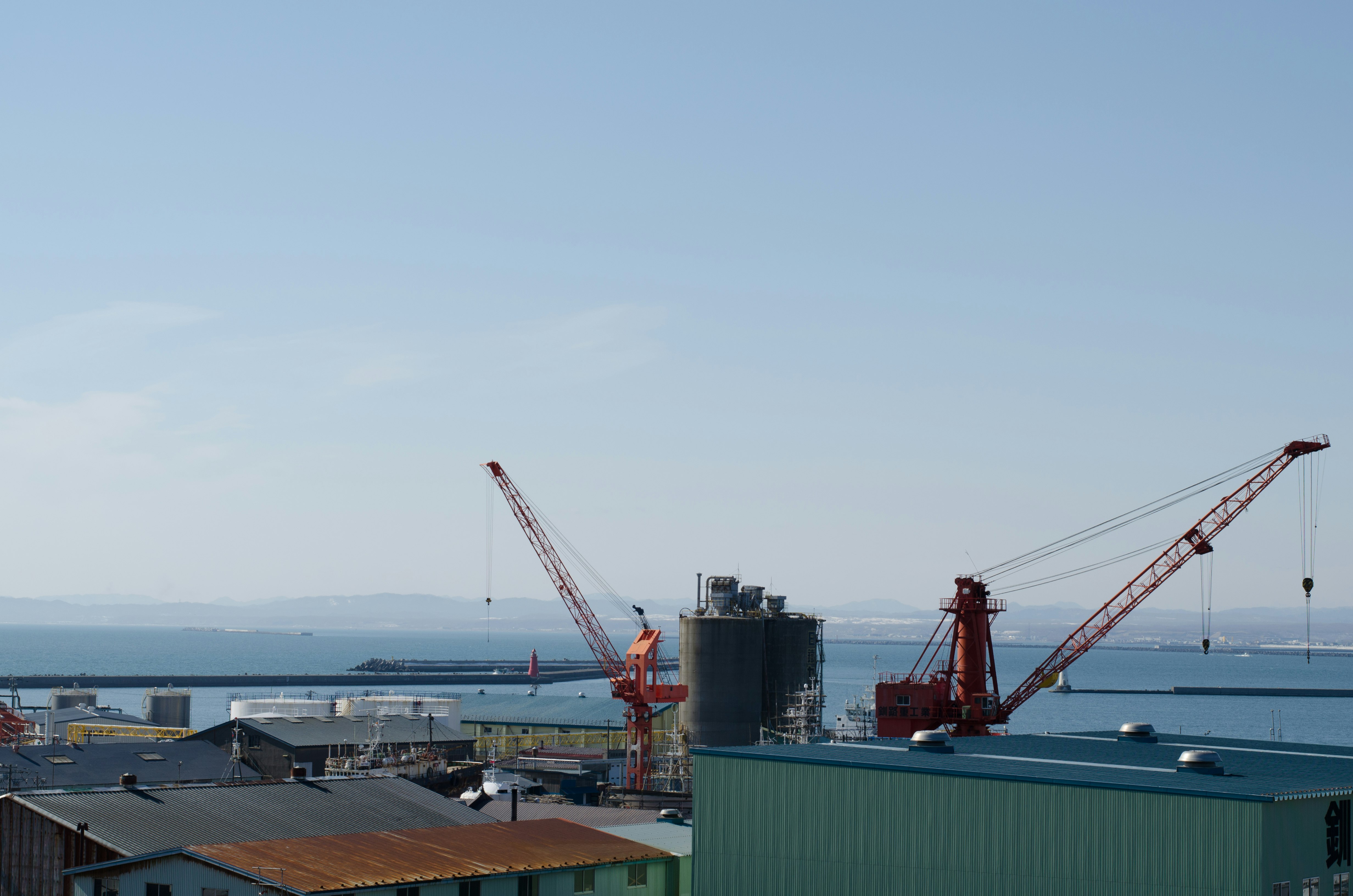 Industriehafen mit Kränen und Blick aufs Meer