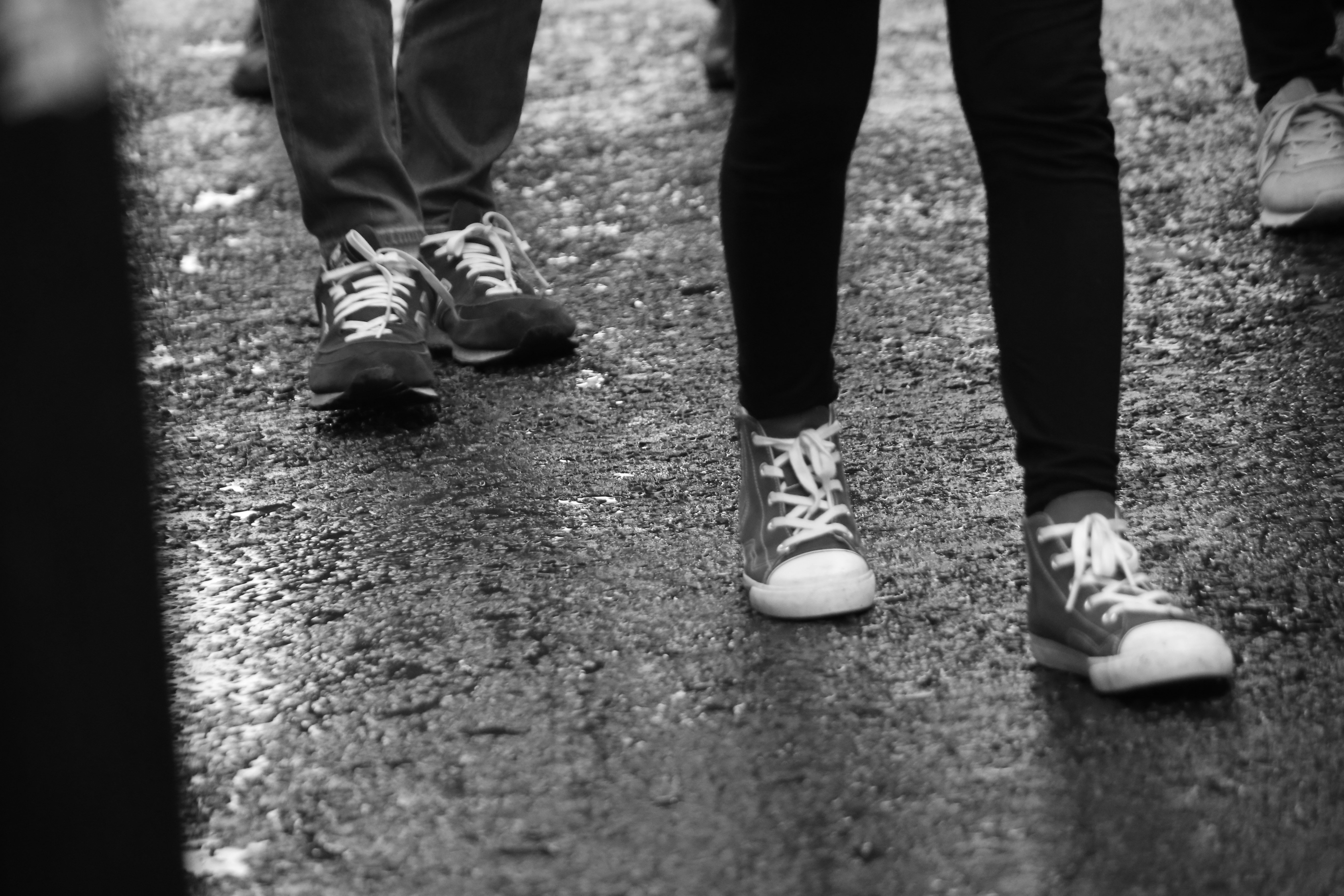 sepatu kets berjalan di trotoar basah setelah hujan