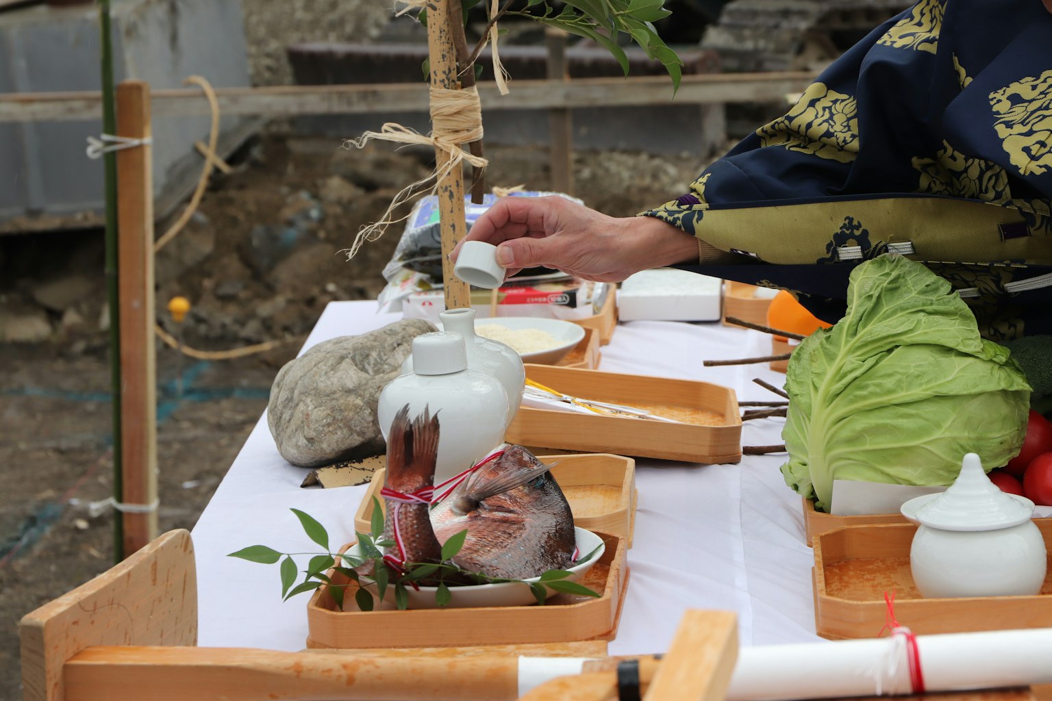 Person reaching for food on a table of festival dishes