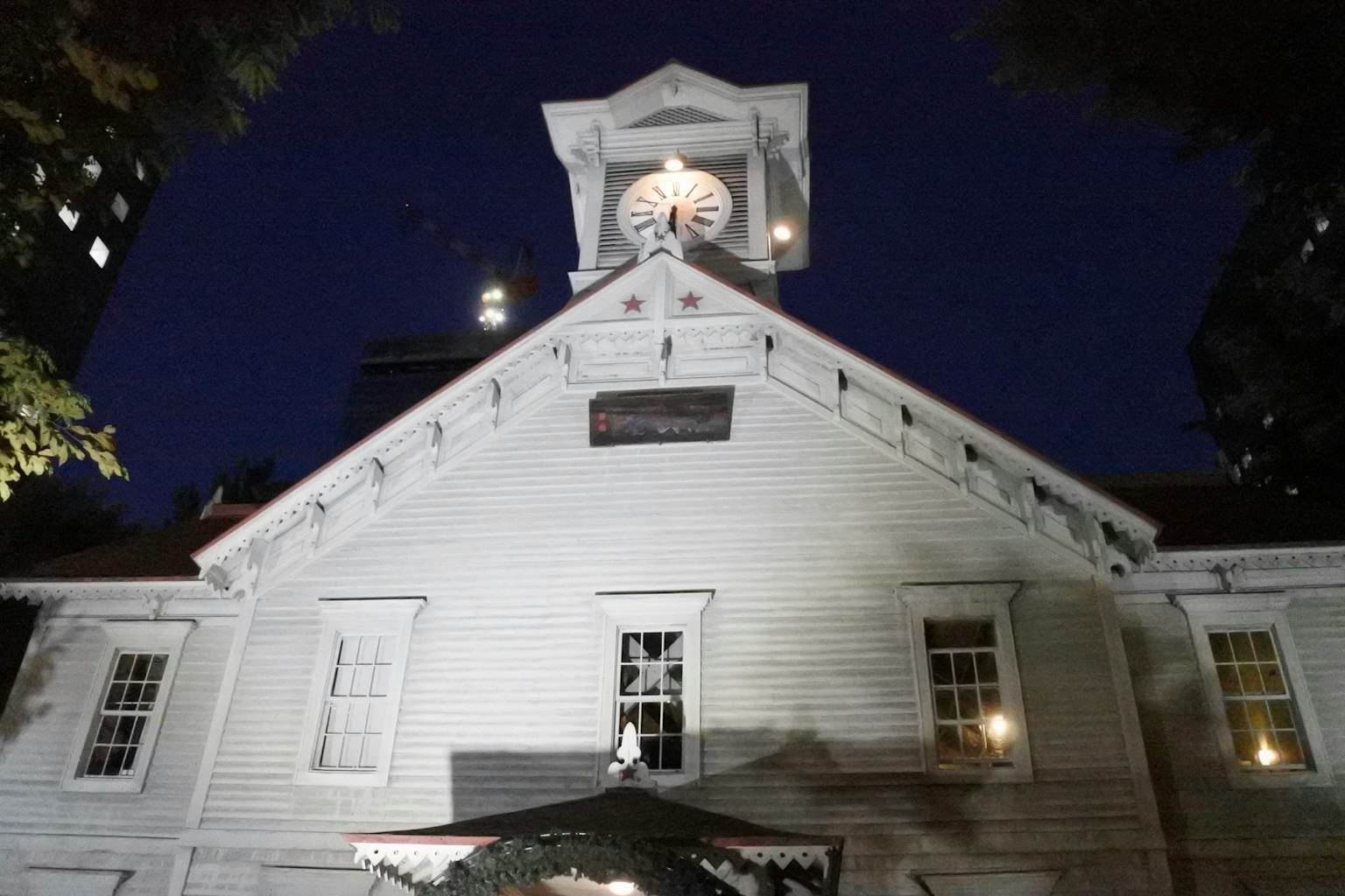 Esterno di un edificio bianco con torre dell'orologio di notte