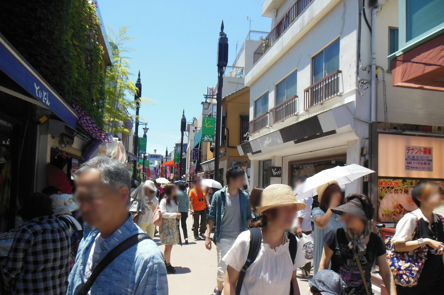 ถนนยุ่งกับผู้คนเดินและร้านค้า