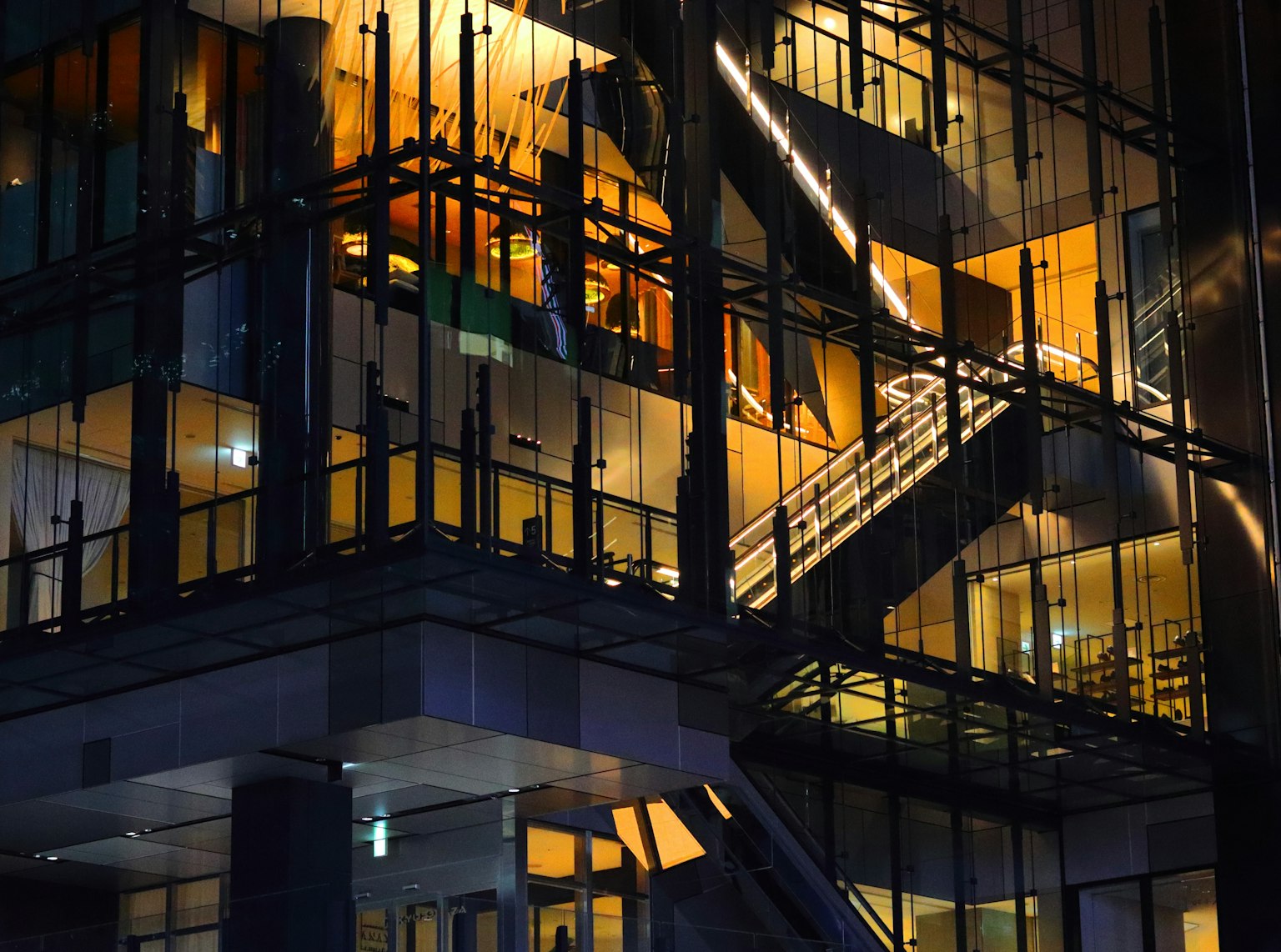 现代建筑的夜景，玻璃外立面和显著的楼梯