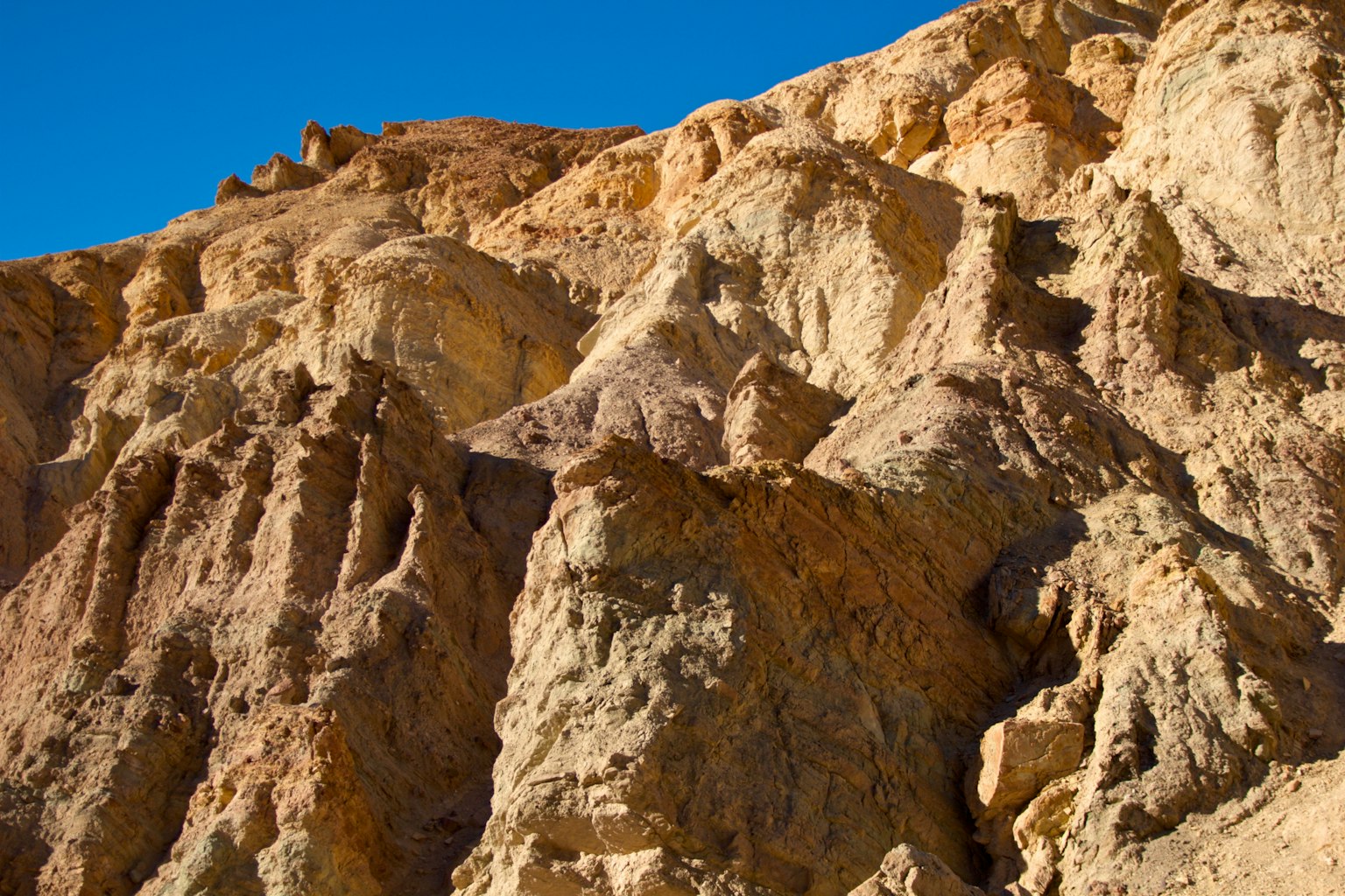 Primo piano di formazioni rocciose a strati sotto un cielo blu chiaro
