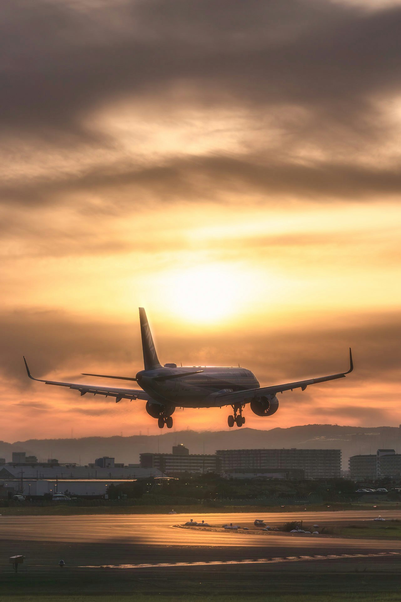夕暮れの滑走路を飛び立つ旅客機のシルエット
