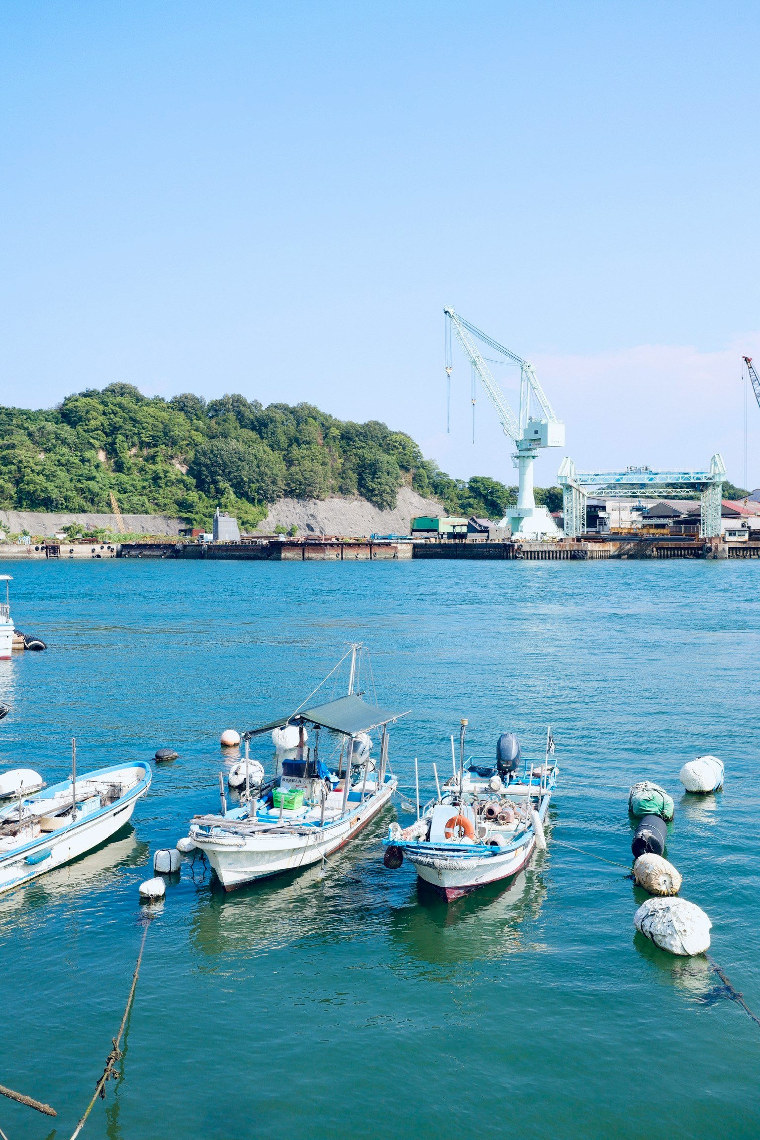 藍色水面上漂浮的漁船和背景中的港口