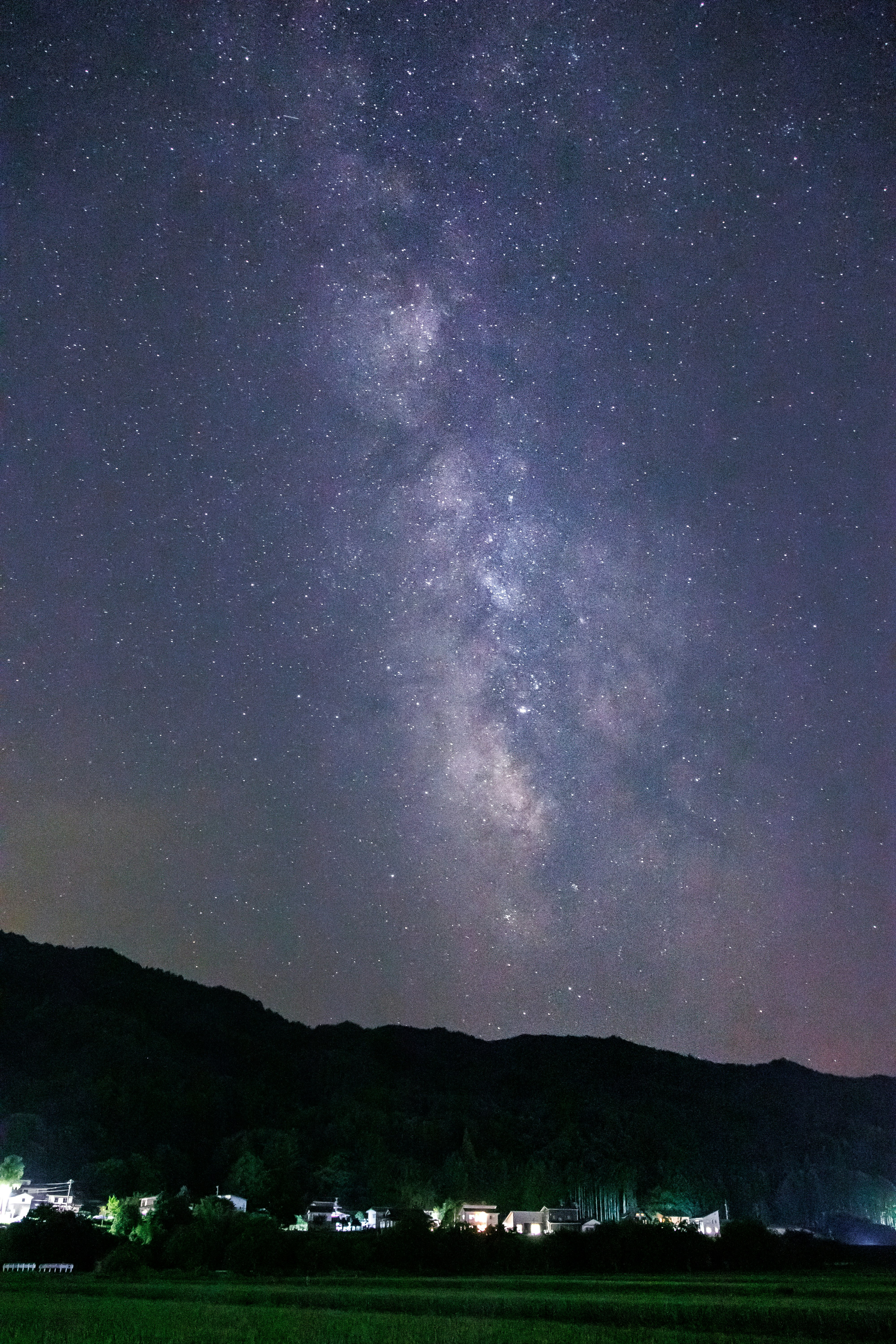 天の川が広がる夜空と山並みの風景