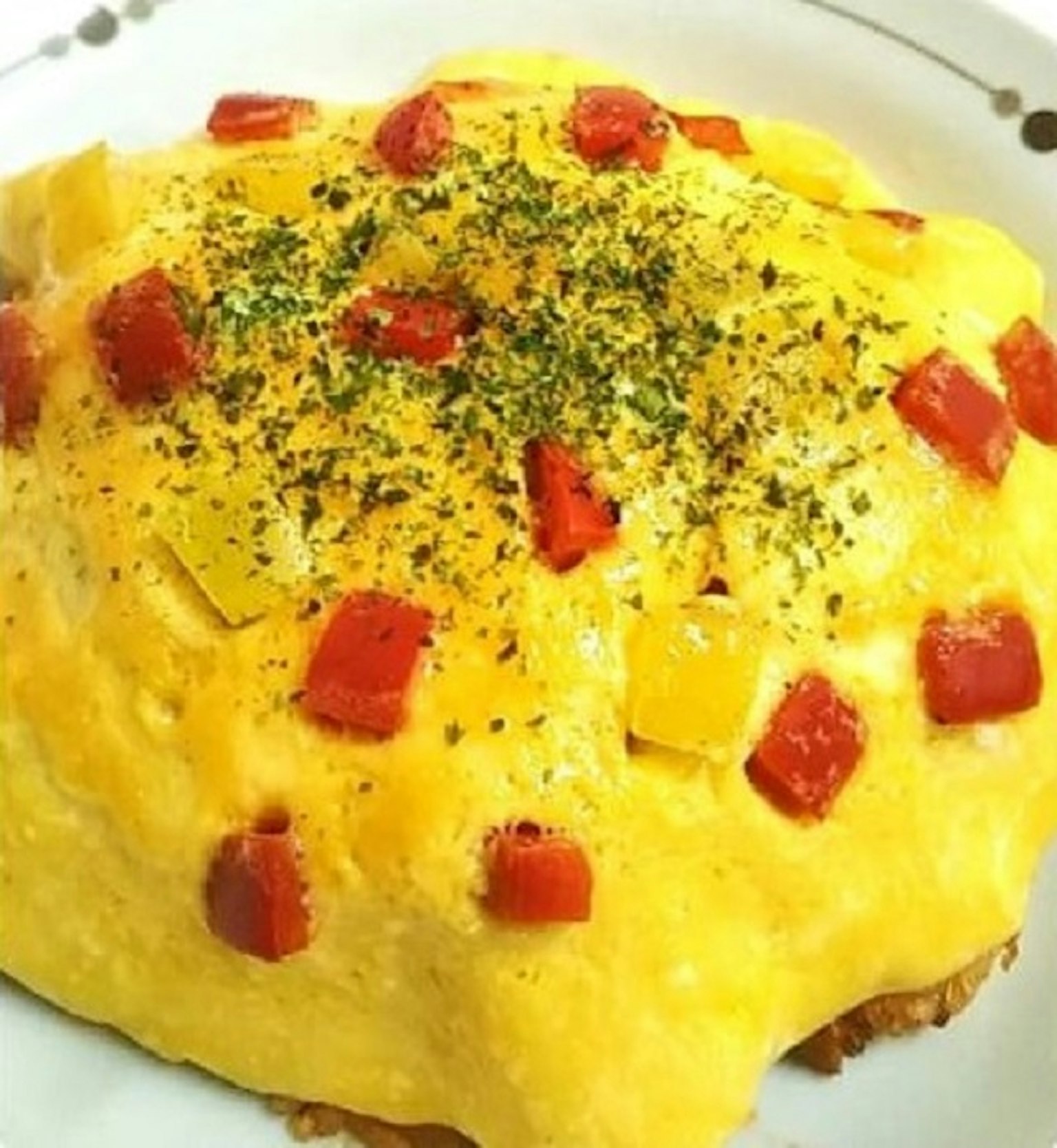 Arroz de omelette esponjoso cubierto con tomates y pimientos en cubos