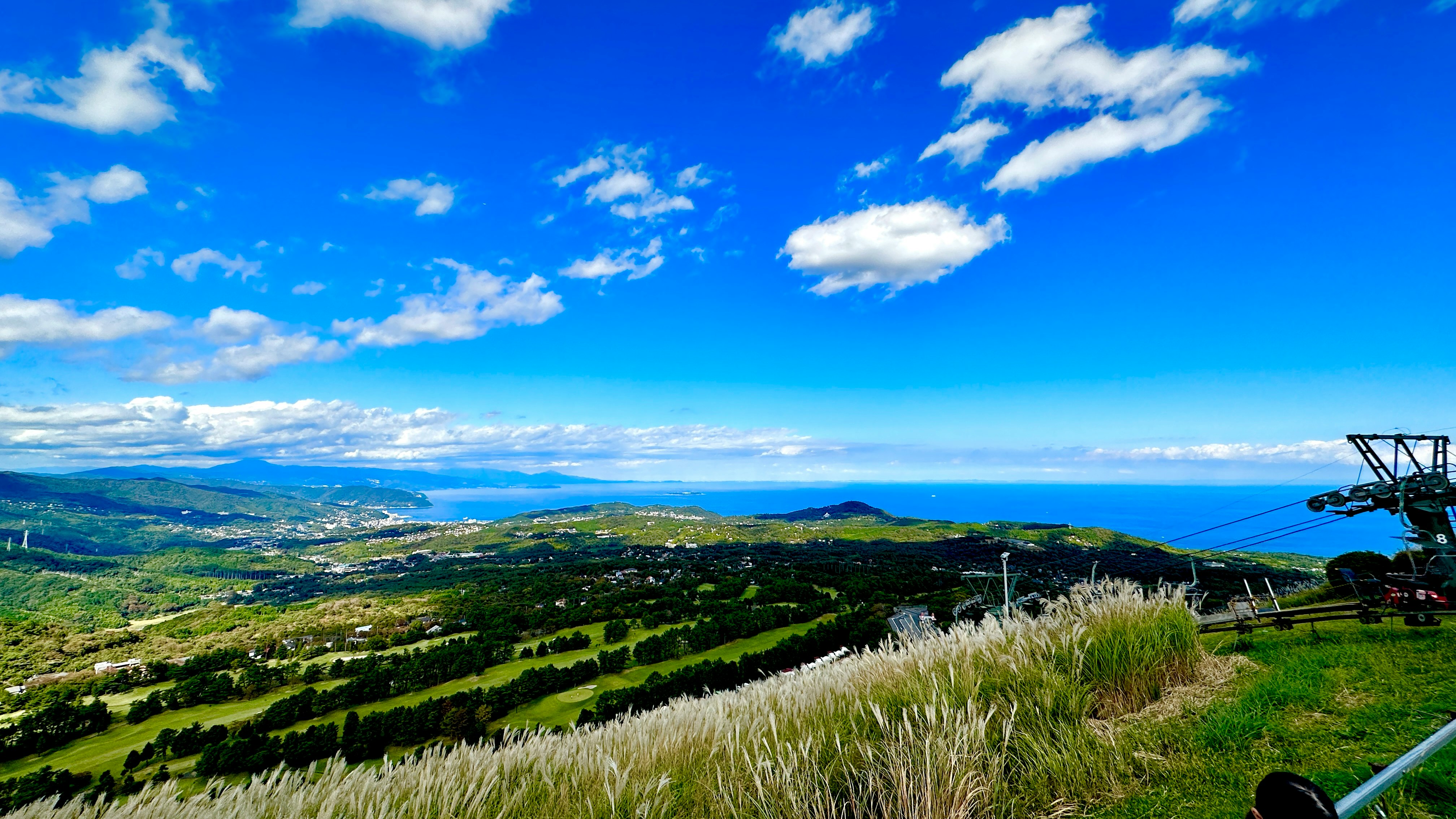草坡山丘俯瞰海面與群山全景