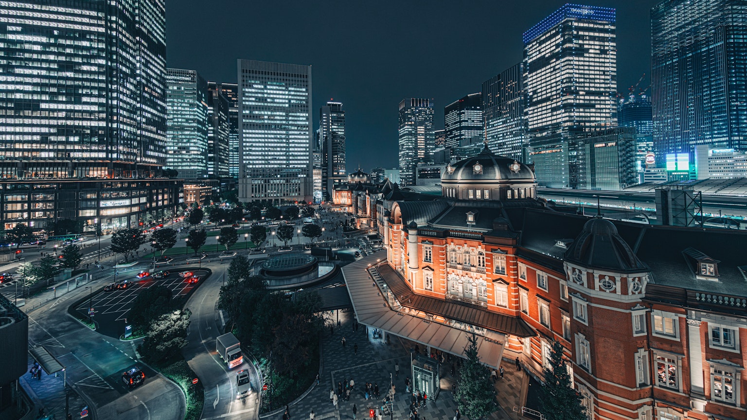 Vista nocturna de la estación de Tokio con rascacielos modernos