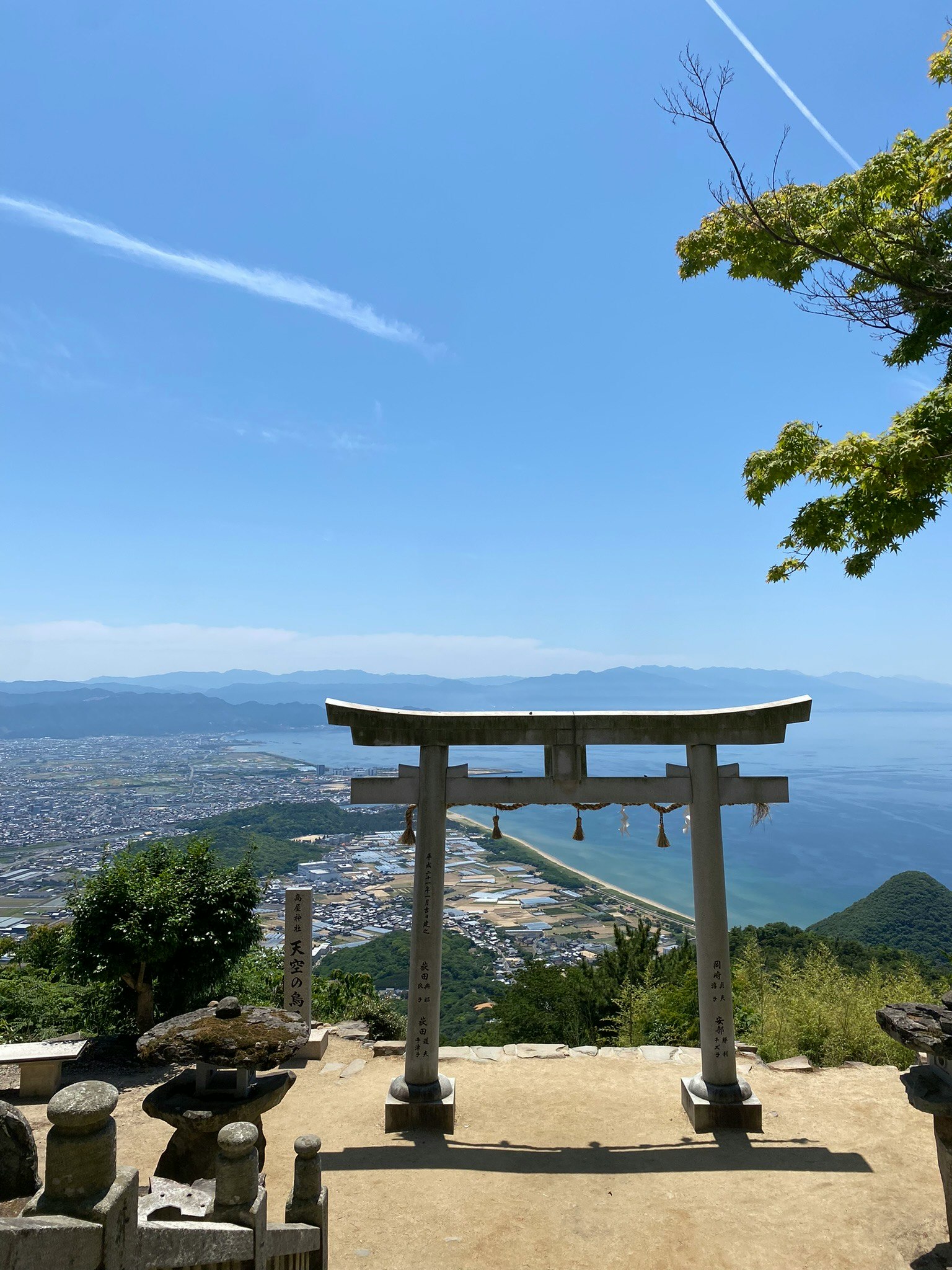 神社鳥居與天空中的飛機航跡