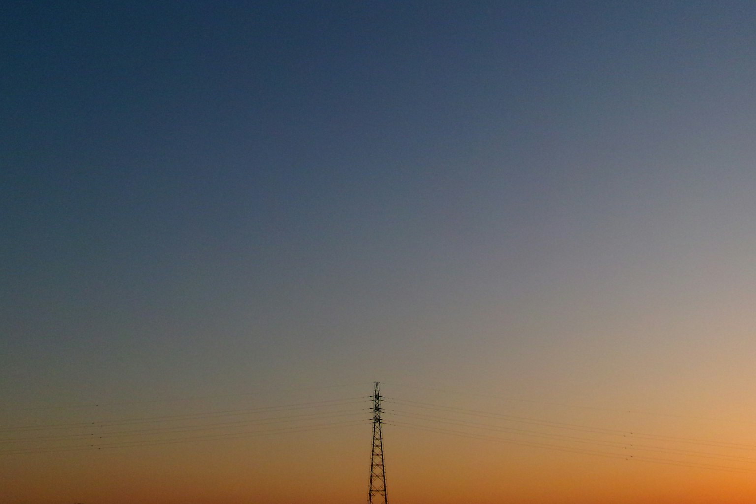 Silueta de una torre de comunicación contra un cielo de atardecer