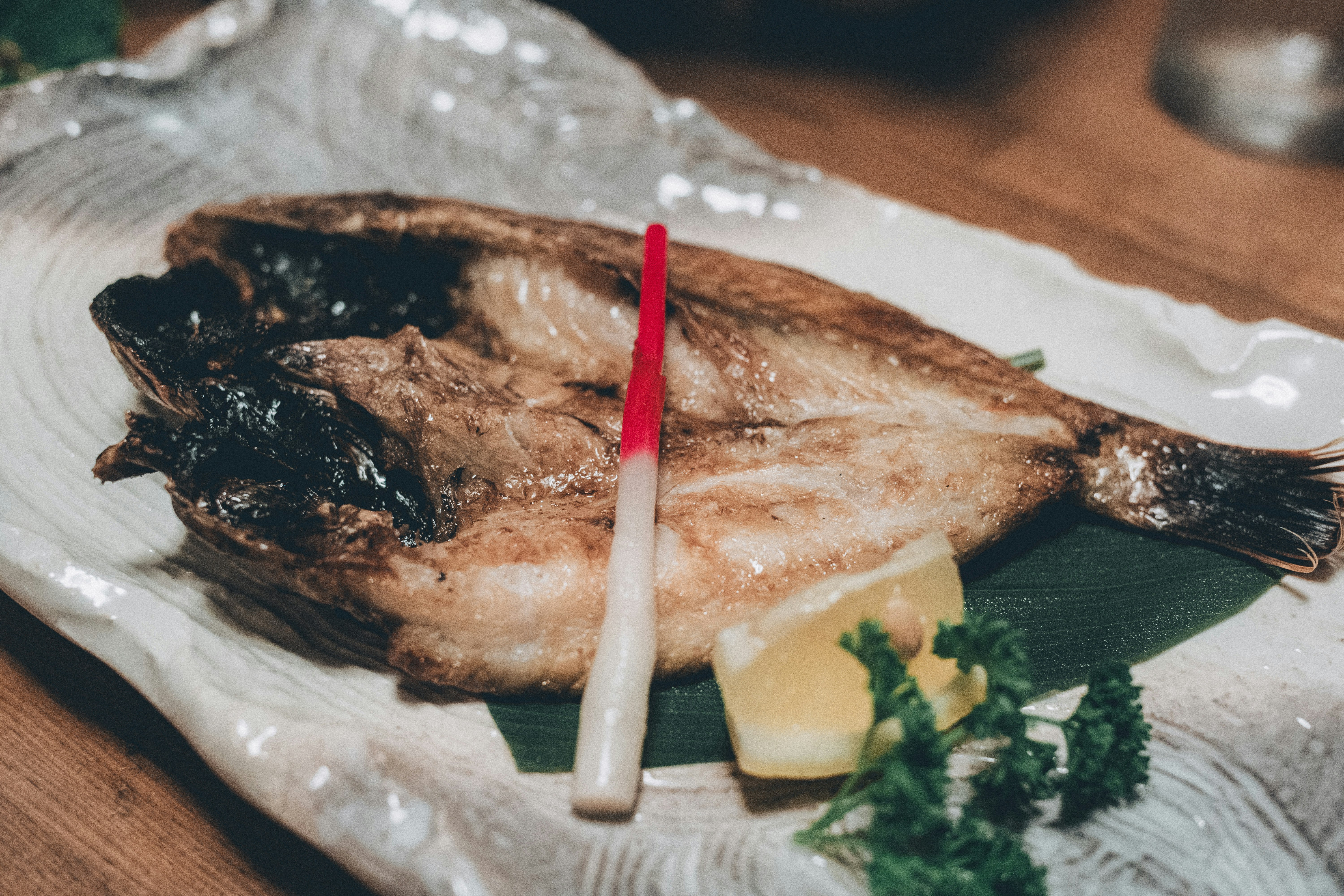 angerichteter gegrillter Fisch mit Beilagen auf dem Tisch