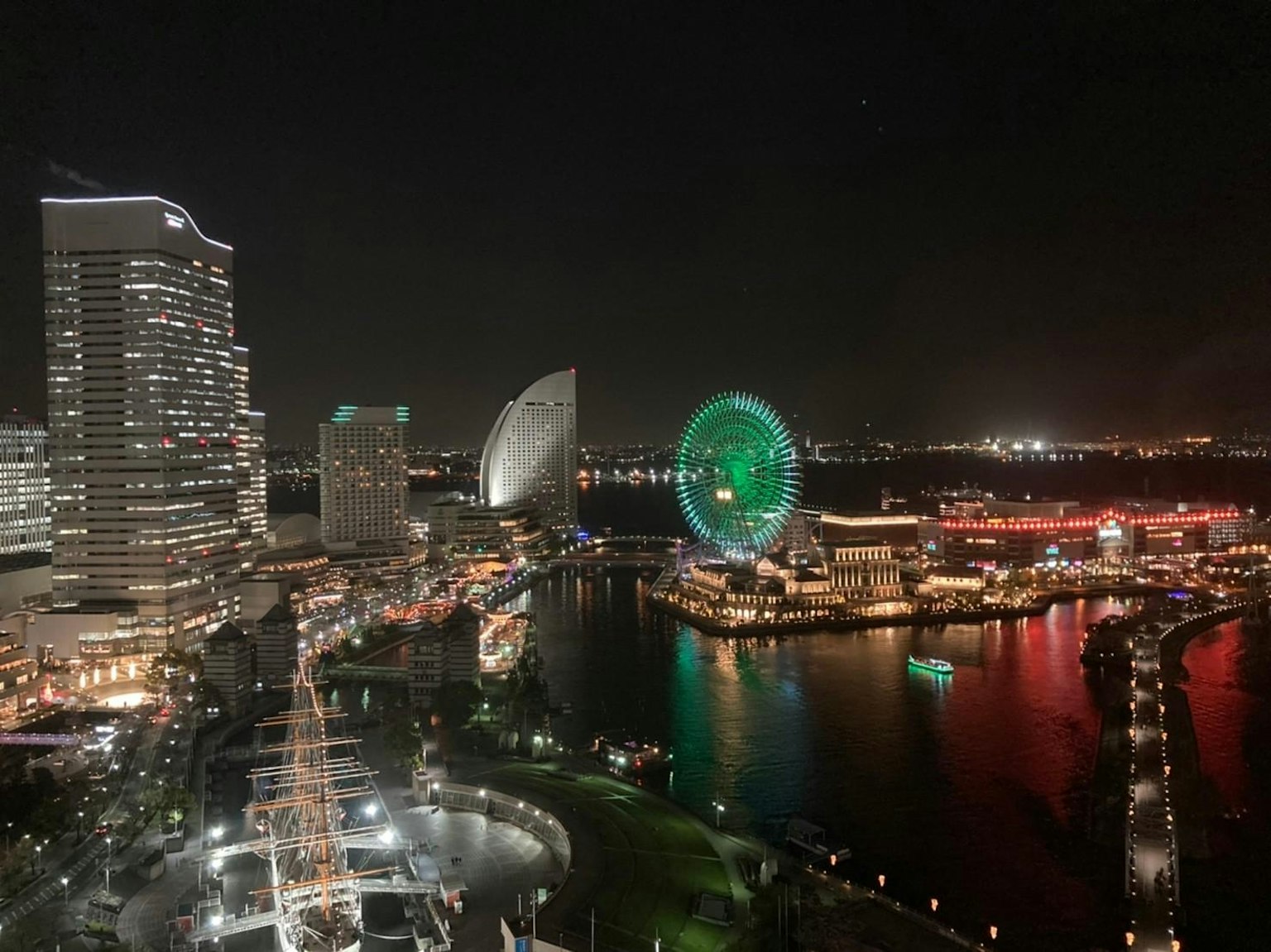 Vista notturna di Yokohama con grattacieli e ruota panoramica illuminata