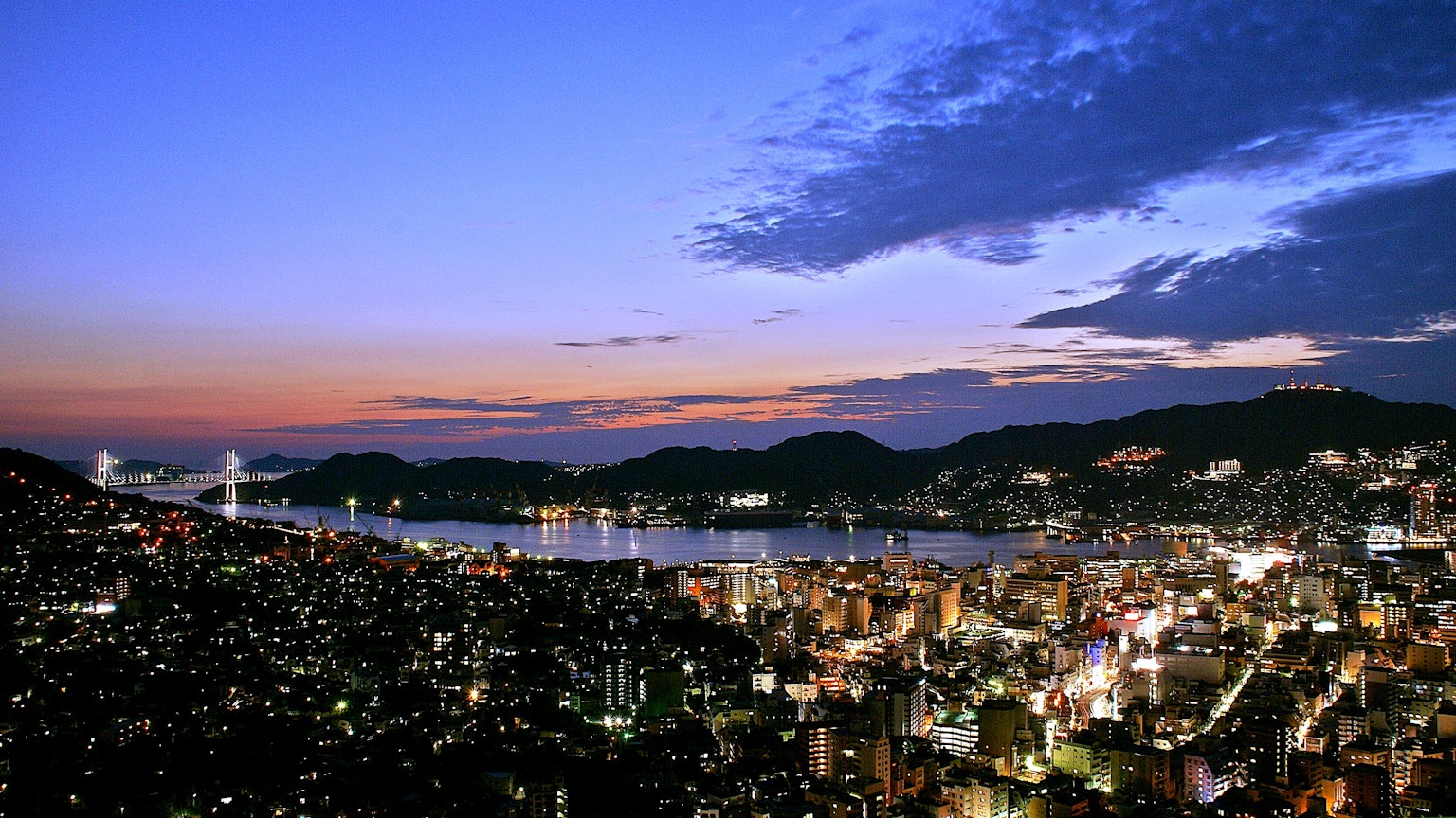 Splendida vista notturna di Nagasaki con il mare e il cielo al tramonto