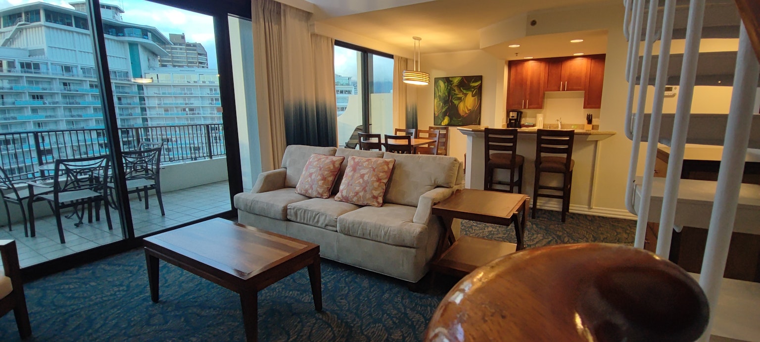 Spacious living room with a sofa and table overlooking the kitchen