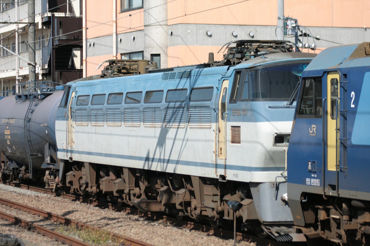 Locomotora eléctrica azul y blanca estacionada en las vías
