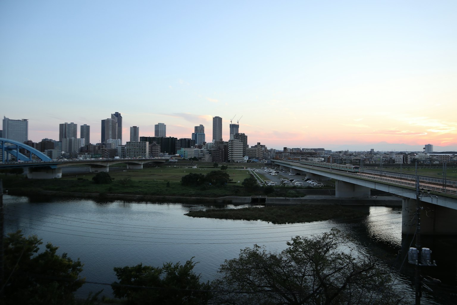 ทิวทัศน์เมืองยามพลบค่ำพร้อมแม่น้ำและสะพาน