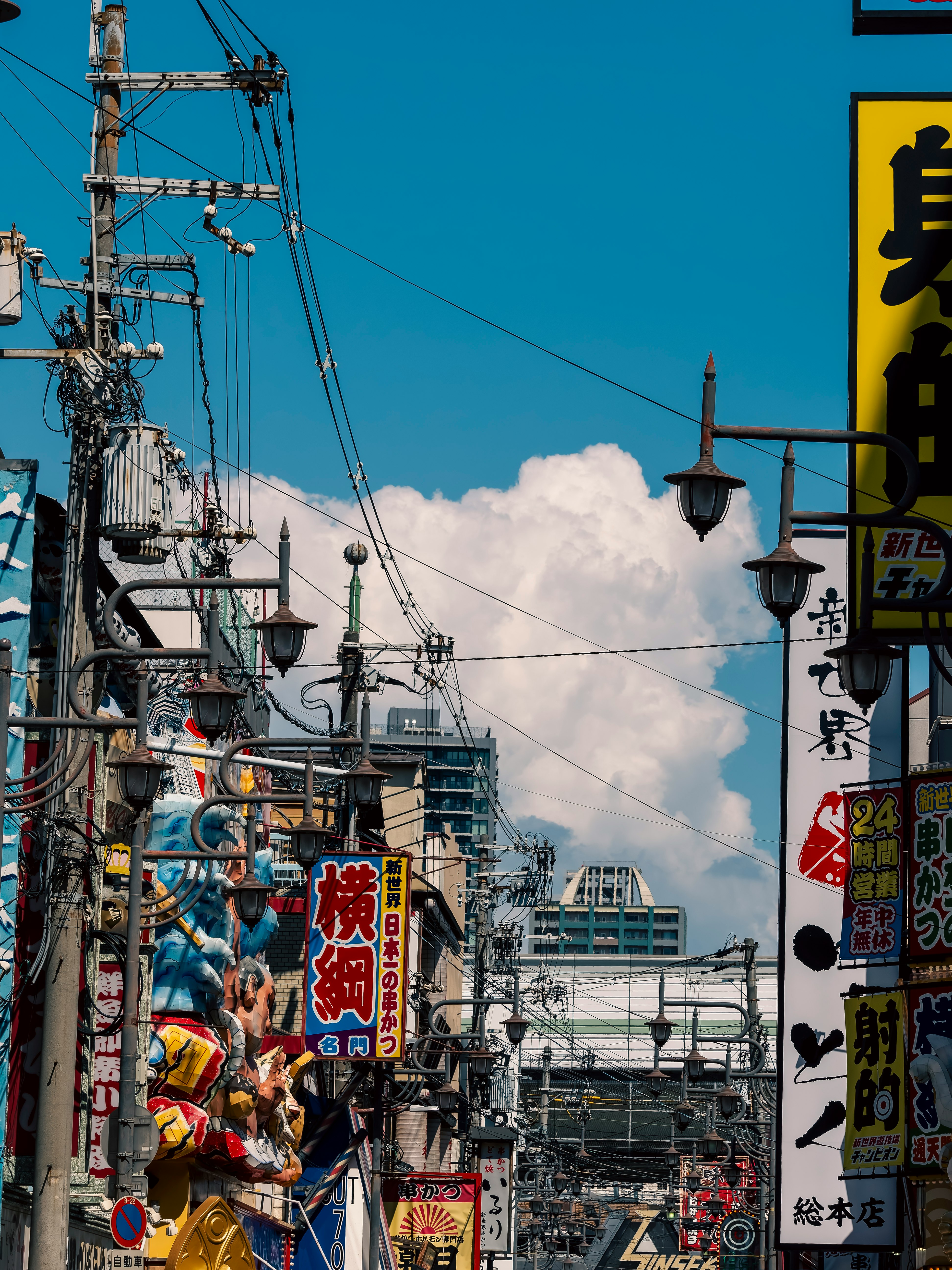 真夏の入道雲が広がる新世界の街並みと電線