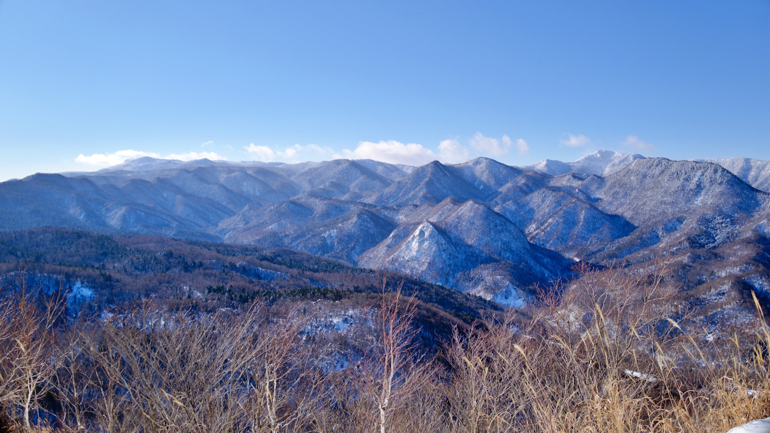 雪覆蓋的山脈在晴朗的藍天下