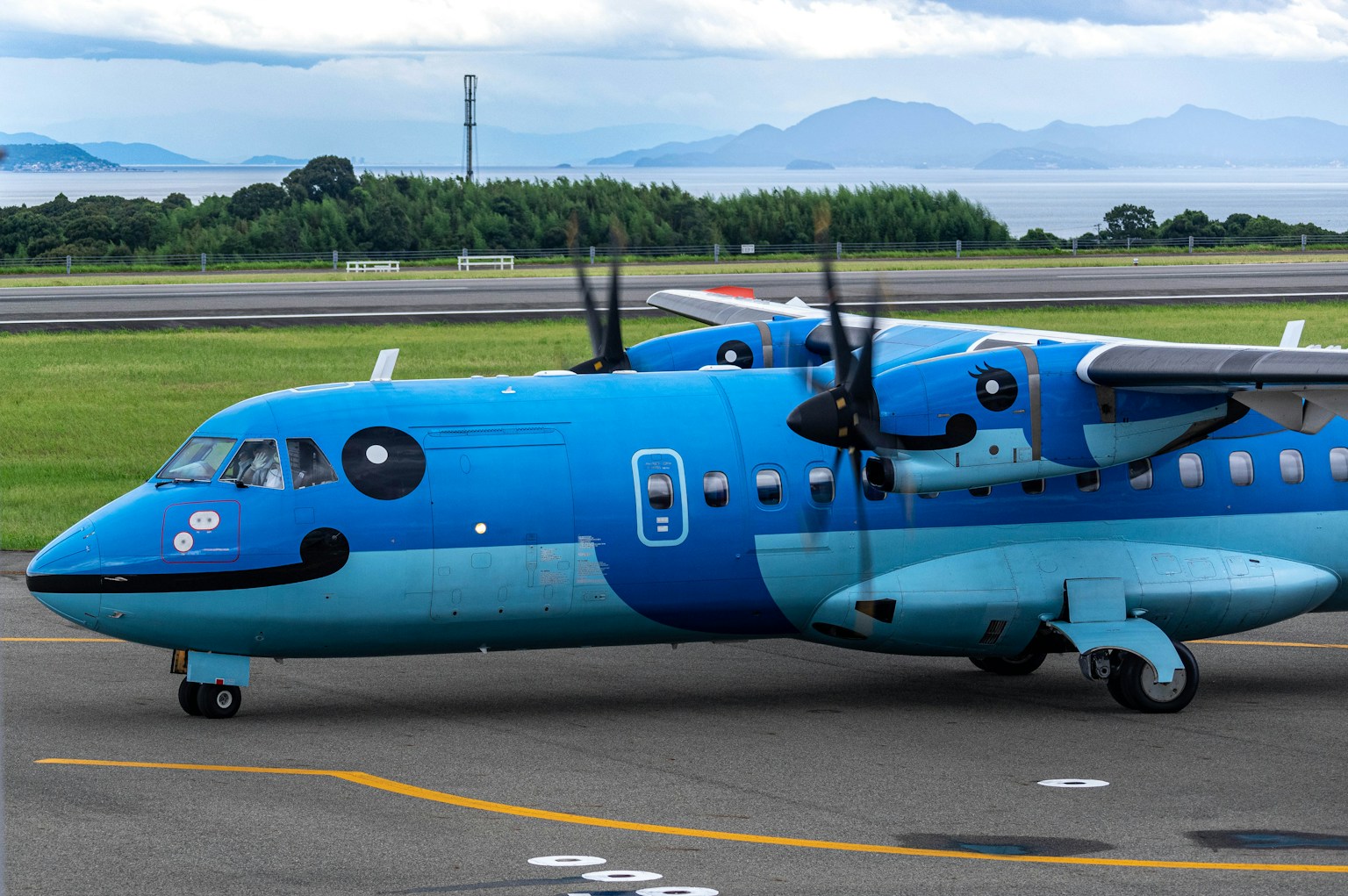 Blaues Propellerflugzeug auf der Landebahn geparkt